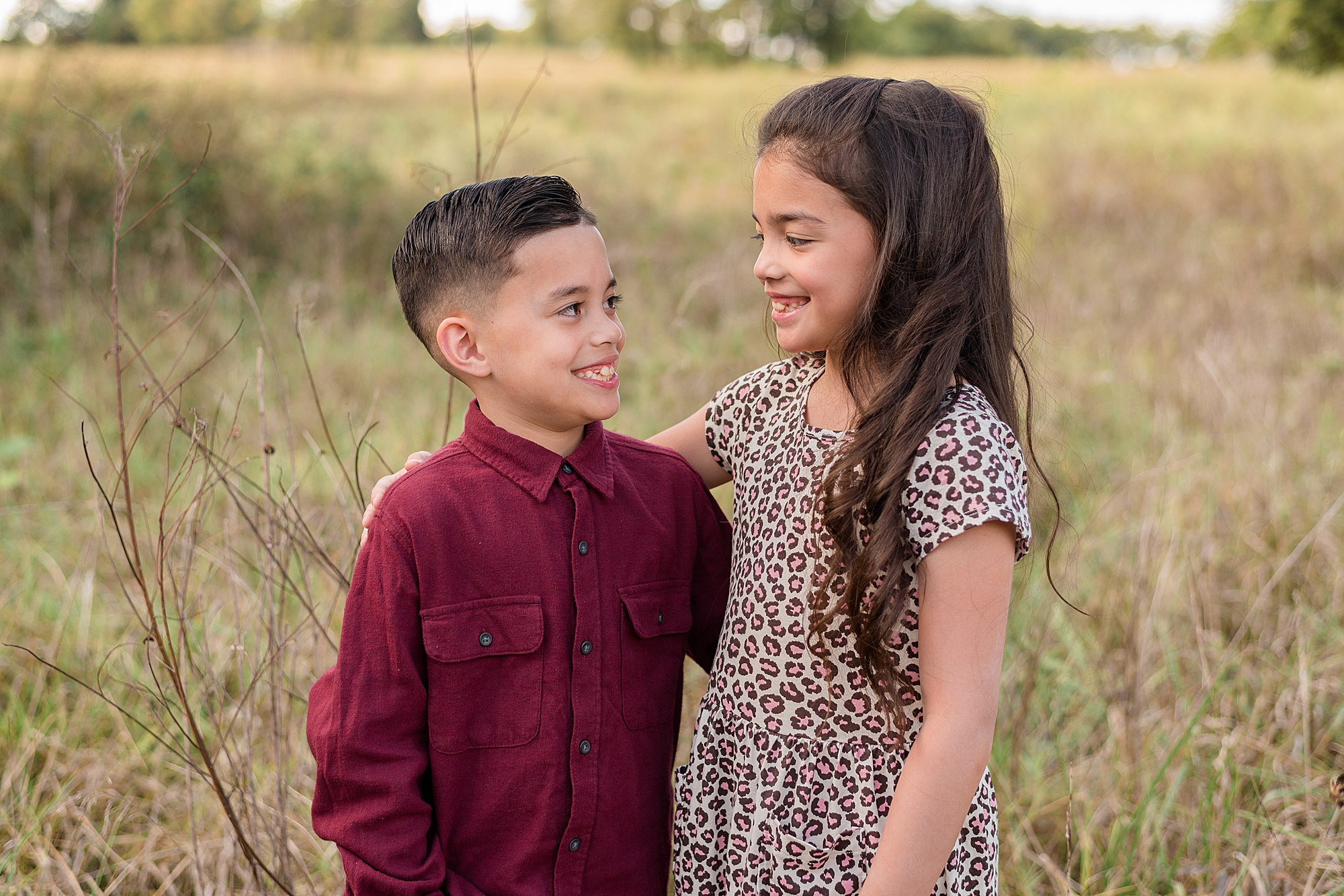brother + Sister have arm around each other during family photos