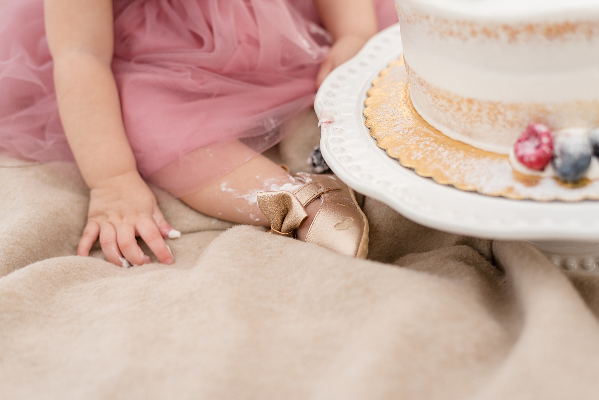 one year old girl with cake on foot during cake smash 