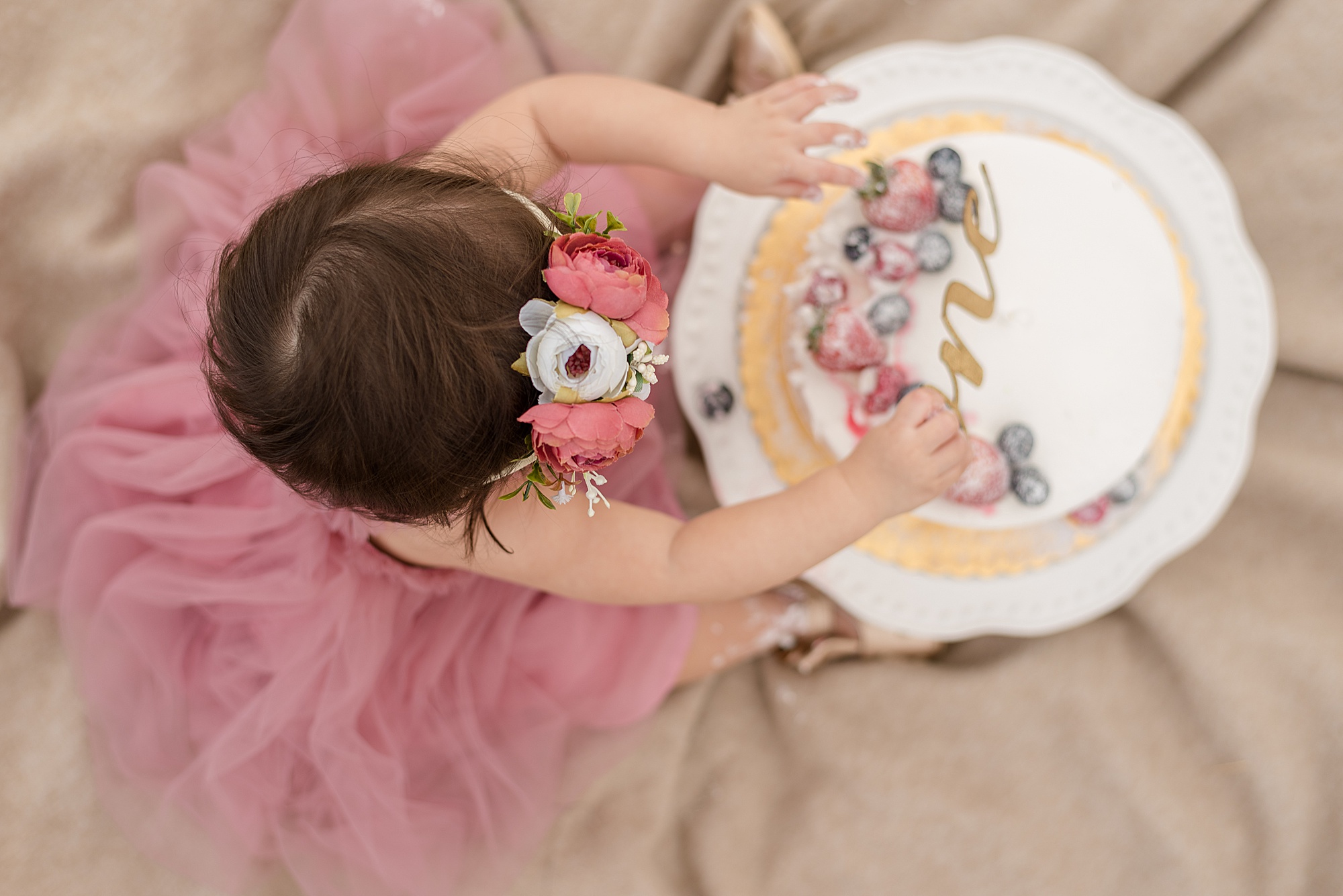 baby girl digs into birthday cake 