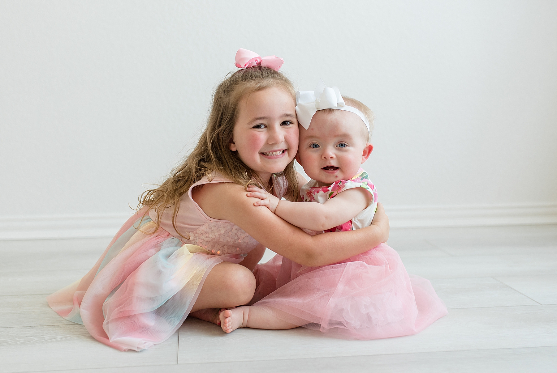 Sisters hugging. Photographed by Dallas newborn photographer Lindsey Dutton Photography