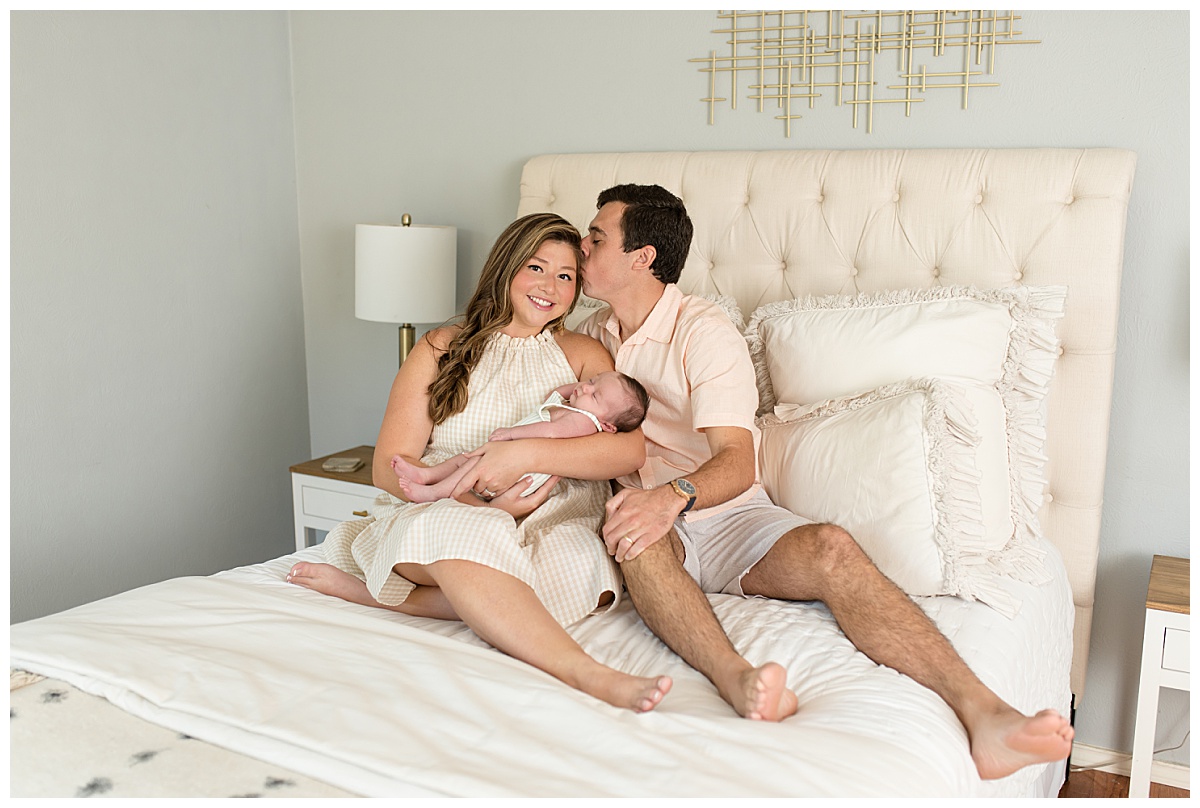 Family at an in-home lifestyle newborn session snuggling on a bed. Photographed by Dallas newborn photographer Lindsey Dutton Photography