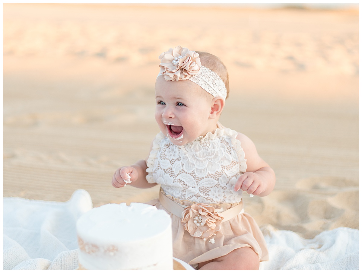 Baby girl eating cake on the beach for her cake smash session in North Dallas by Lindsey Dutton Photography, a Dallas Cake Smash Photographer. 