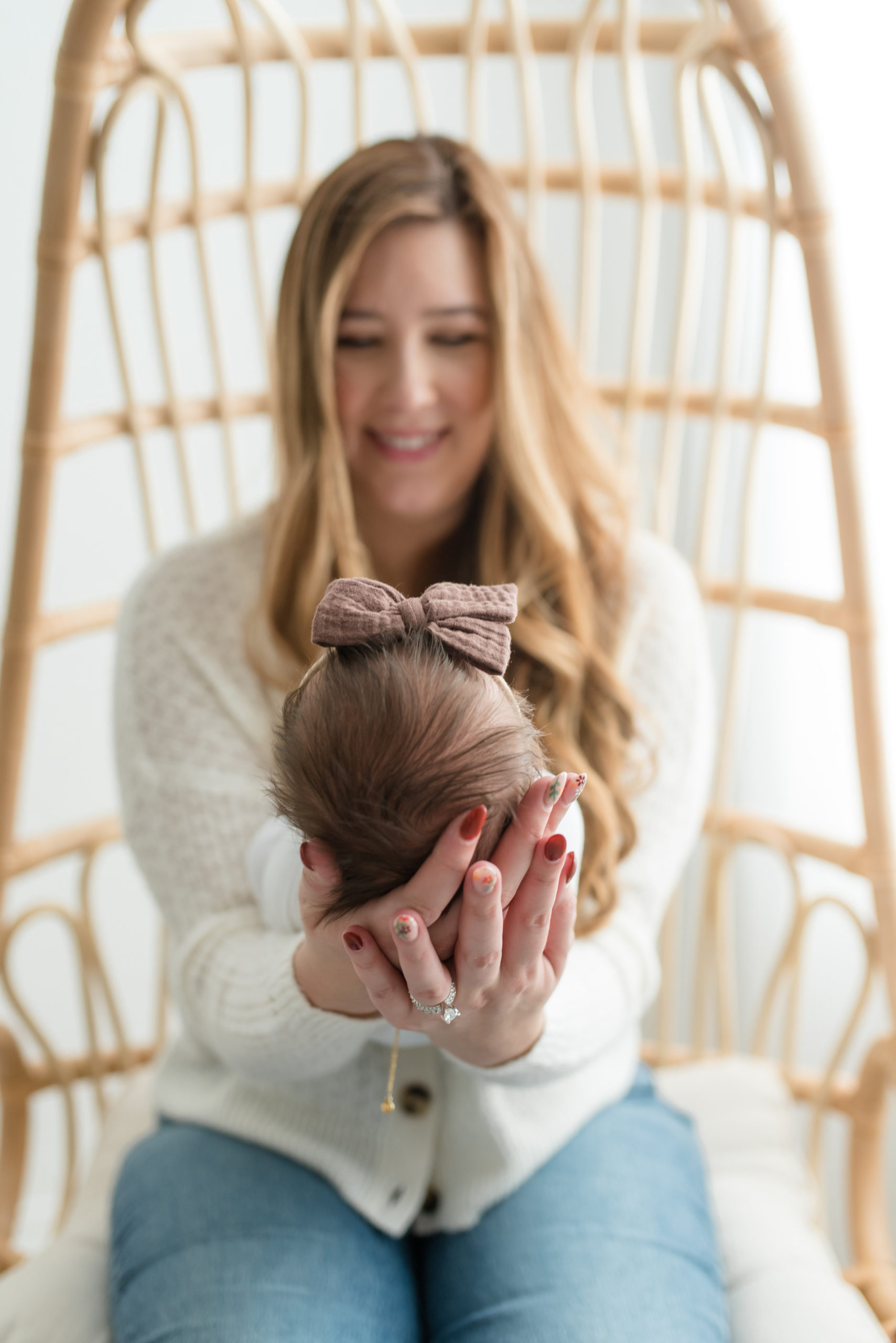 Mom holding baby girl in her hands at an in-studi newborn session. Photographed by Dallas newborn photographer Lindsey Dutton Photography