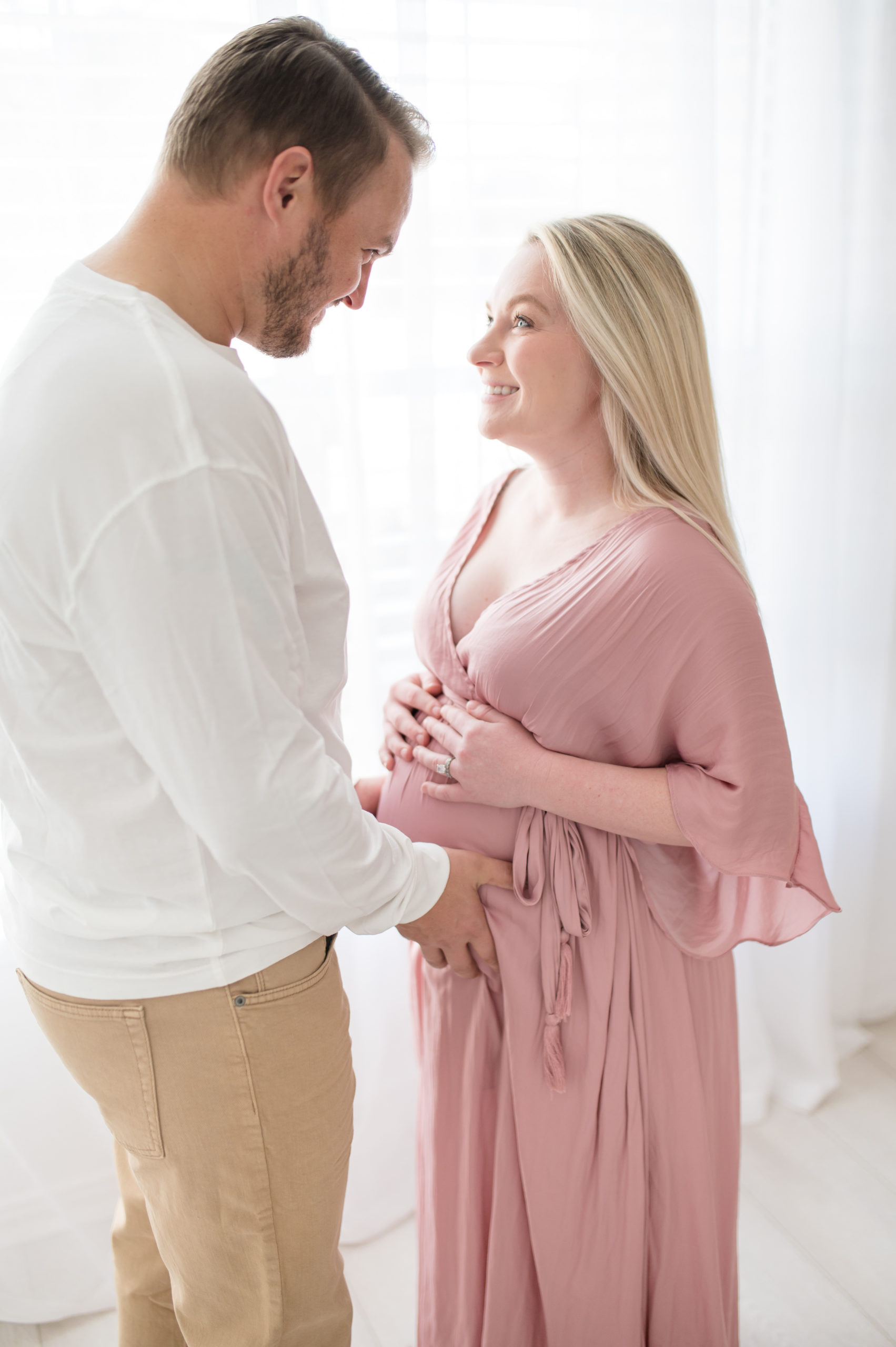 Pregnant mom and dad holding baby bump at an in studio in Dallas Texas photographed by Dallas newborn photographer, Lindsey Dutton Photography