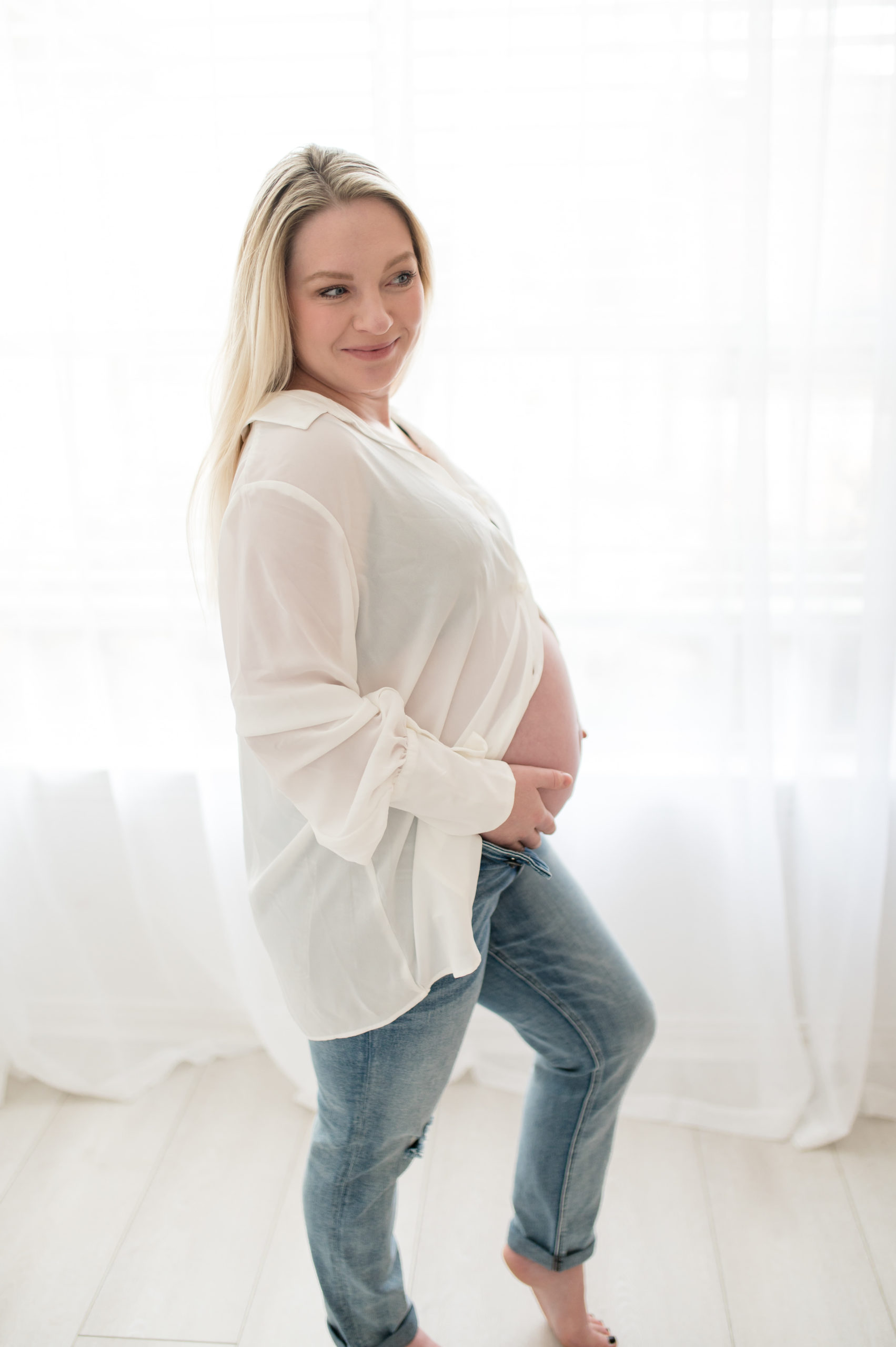 Mother in a casual outfit during maternity session in studio in Dallas Texas 