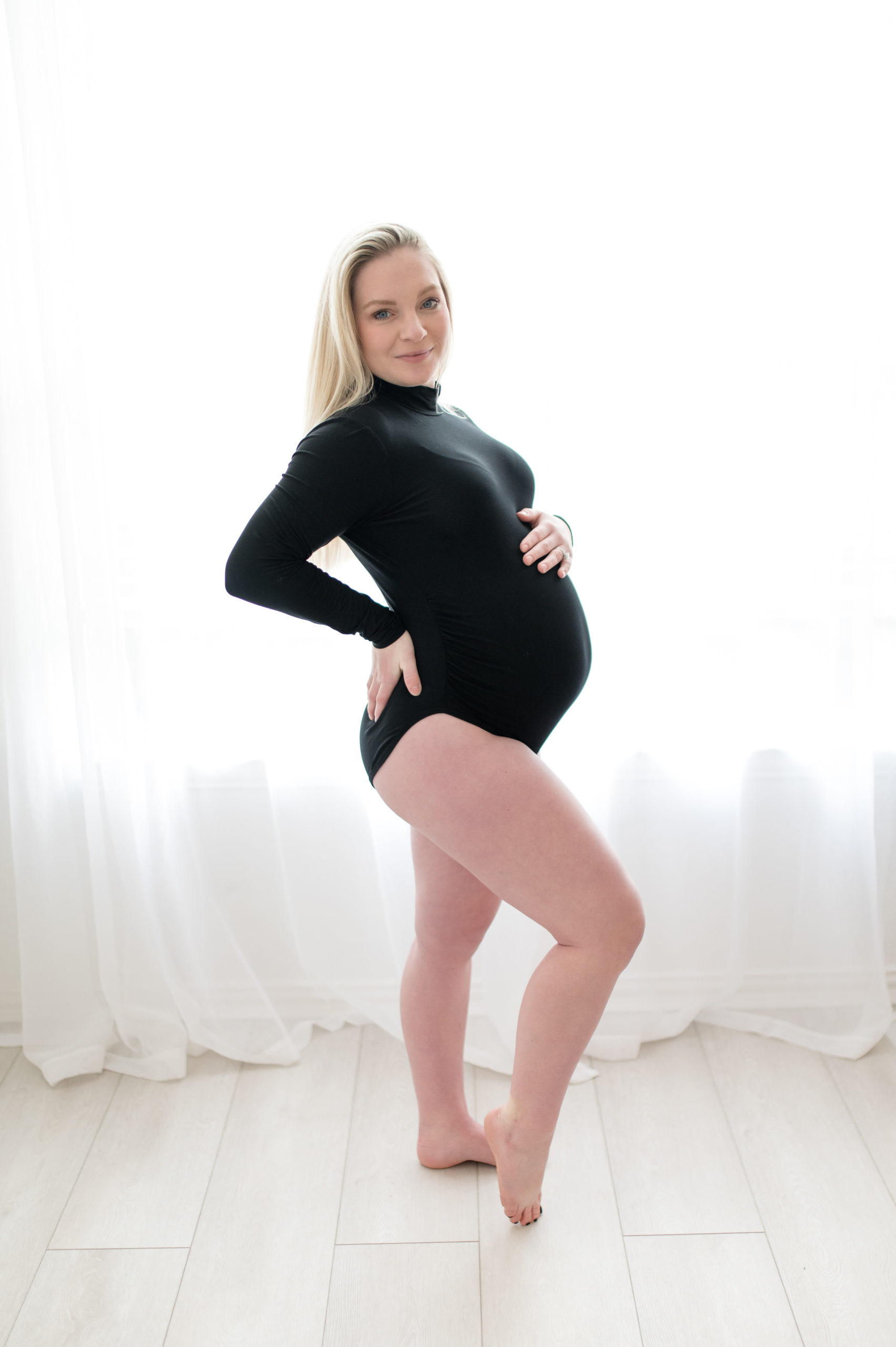 pregnant women in black body suit in a classy in studio maternity session 