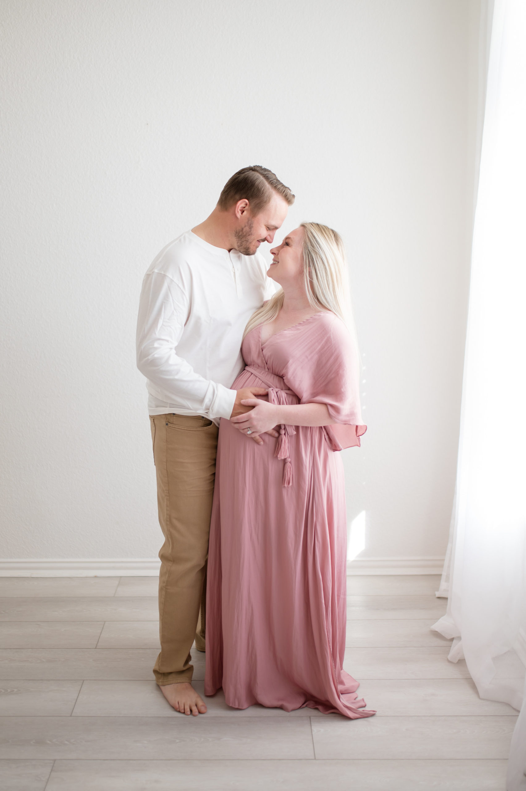 Pregnant mom and dad nose to nose holding belly photographed by Dallas newborn photographer, Lindsey Dutton Photography