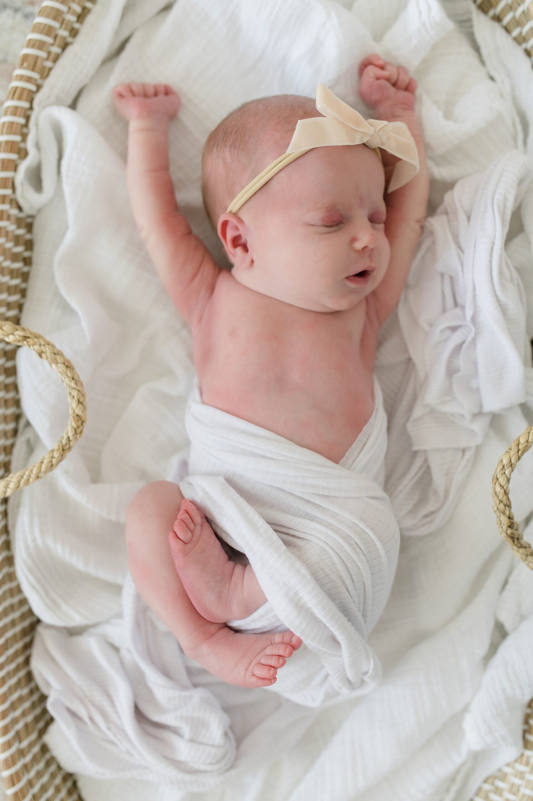 baby girl stretches out as she sleeps during in-home lifestyle newborn session