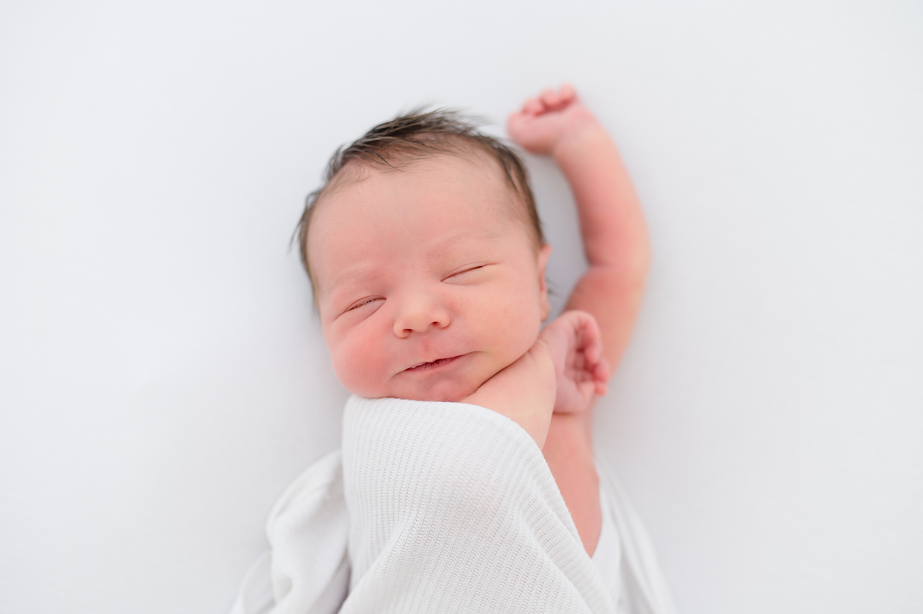 newborn gives sleepy smile