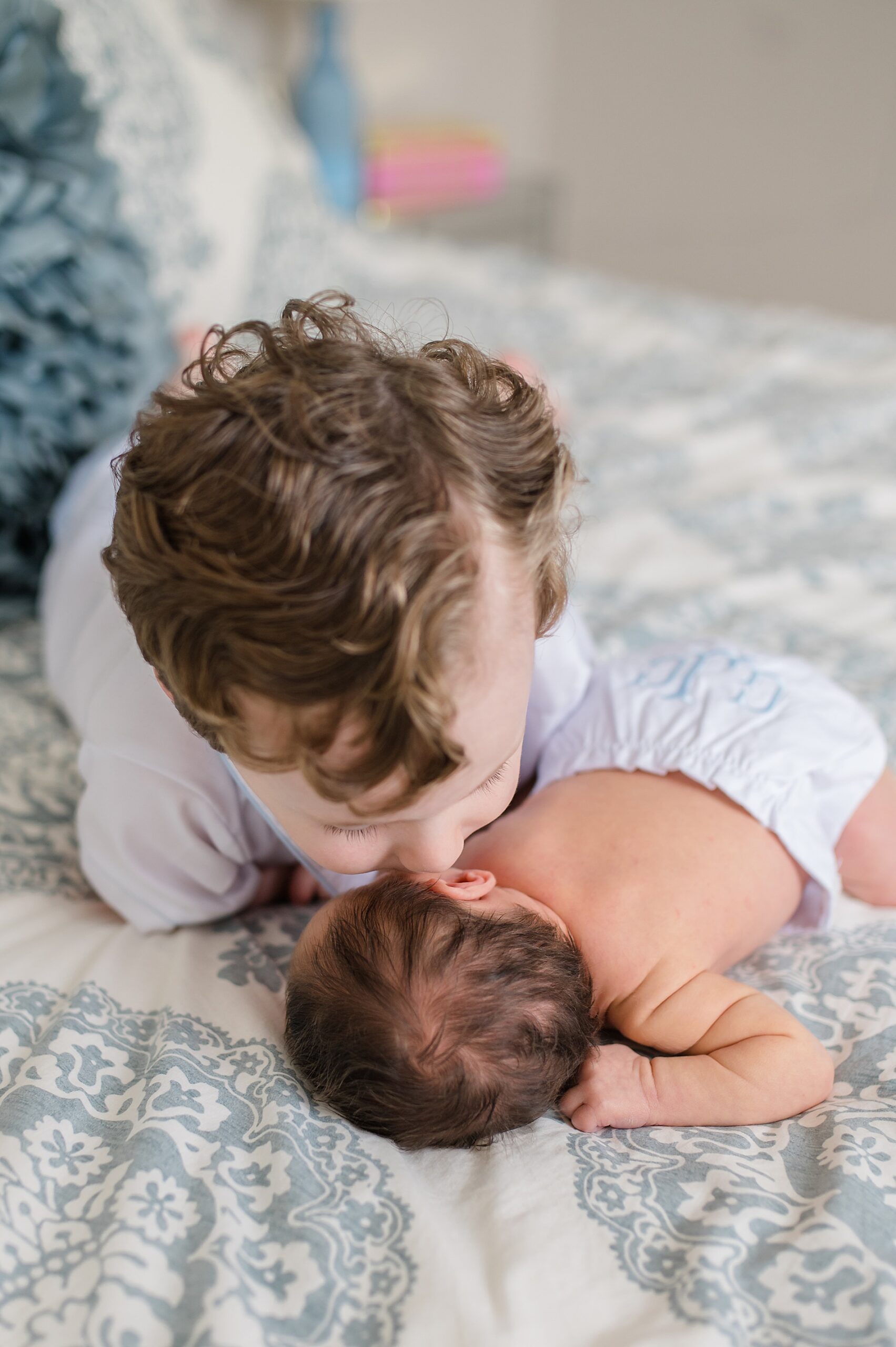 older brother kisses newborn brother   photographed by Lindsey Dutton Photography, a Dallas Newborn photographer