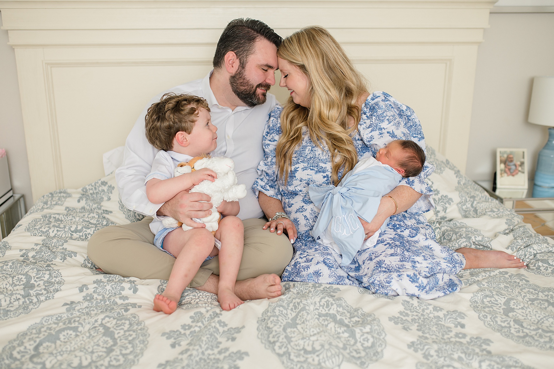 Family snuggling on bed photographed by Lindsey Dutton Photography, a Dallas Newborn photographer