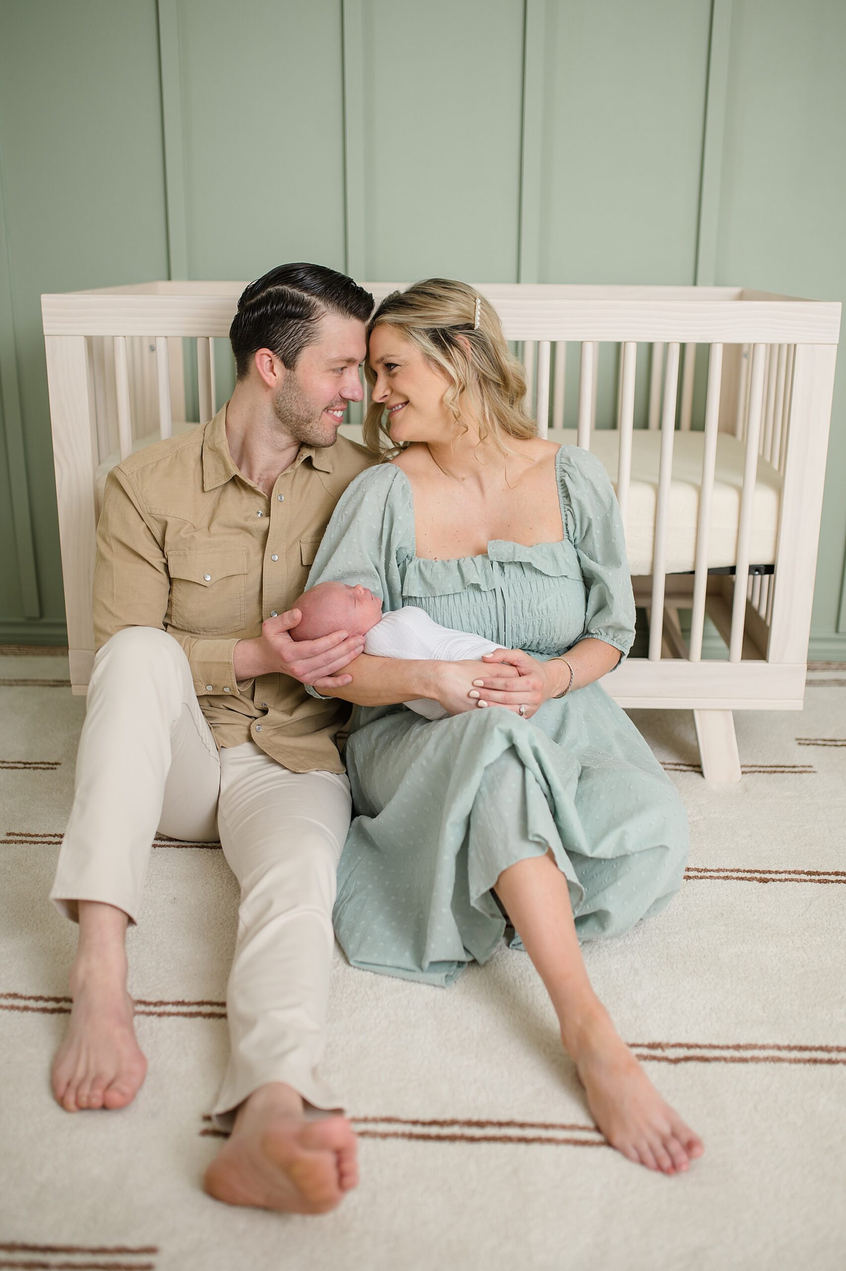 parents sit on floor of nursery during Cozy In-Home Newborn Session photographed by Lindsey Dutton Photography, a Dallas Newborn photographer
