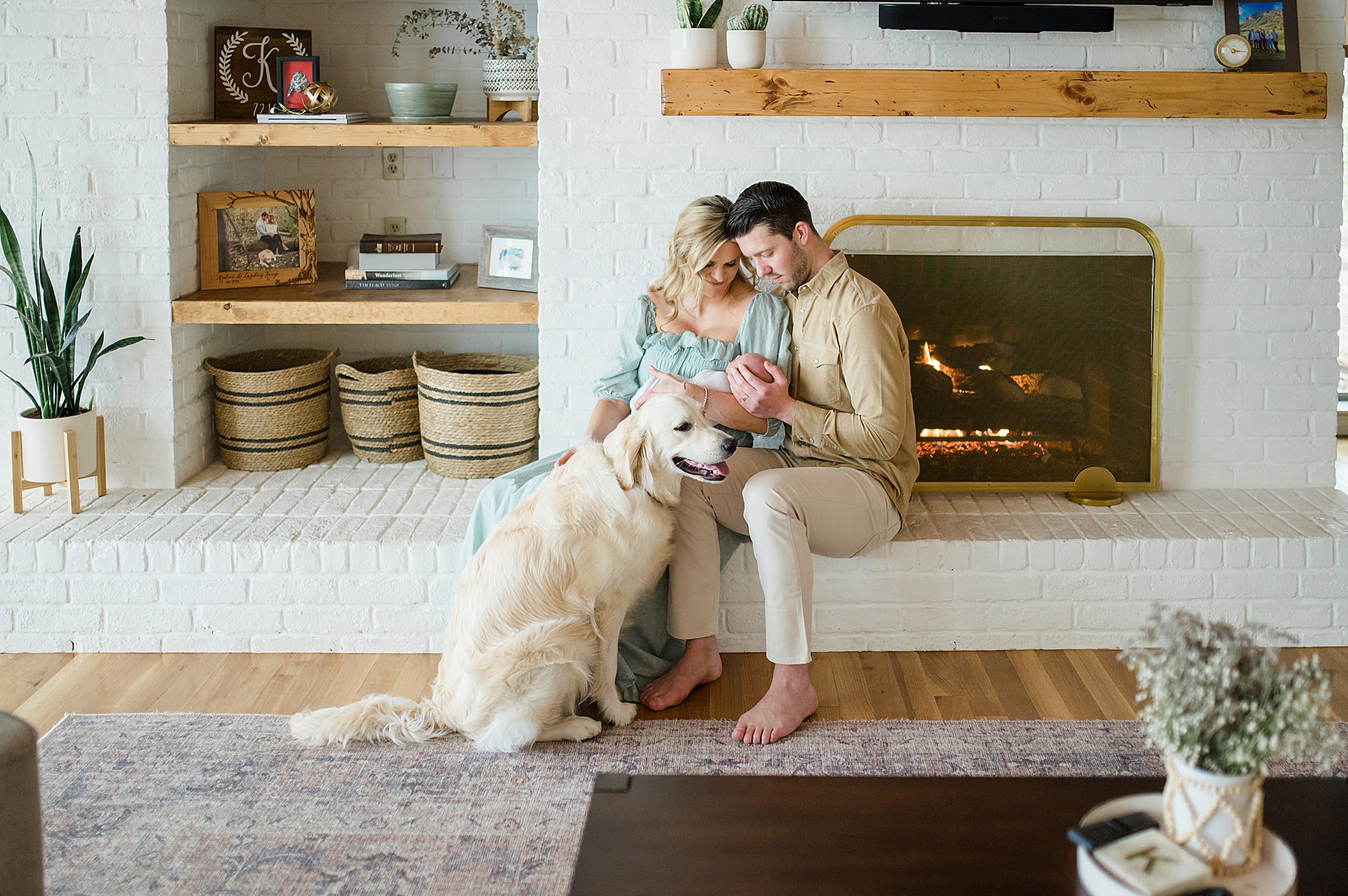 family snuggle newborn son by fireplace during Cozy In-Home Newborn Session photographed by Lindsey Dutton Photography, a Dallas Newborn photographer
