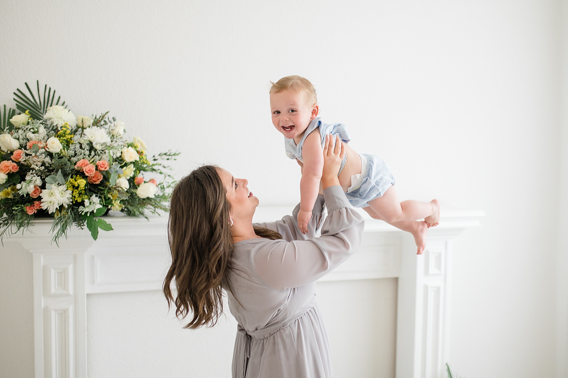 mom lifts her son up in the air taken by Lindsey Dutton Photography, a Dallas newborn photographer