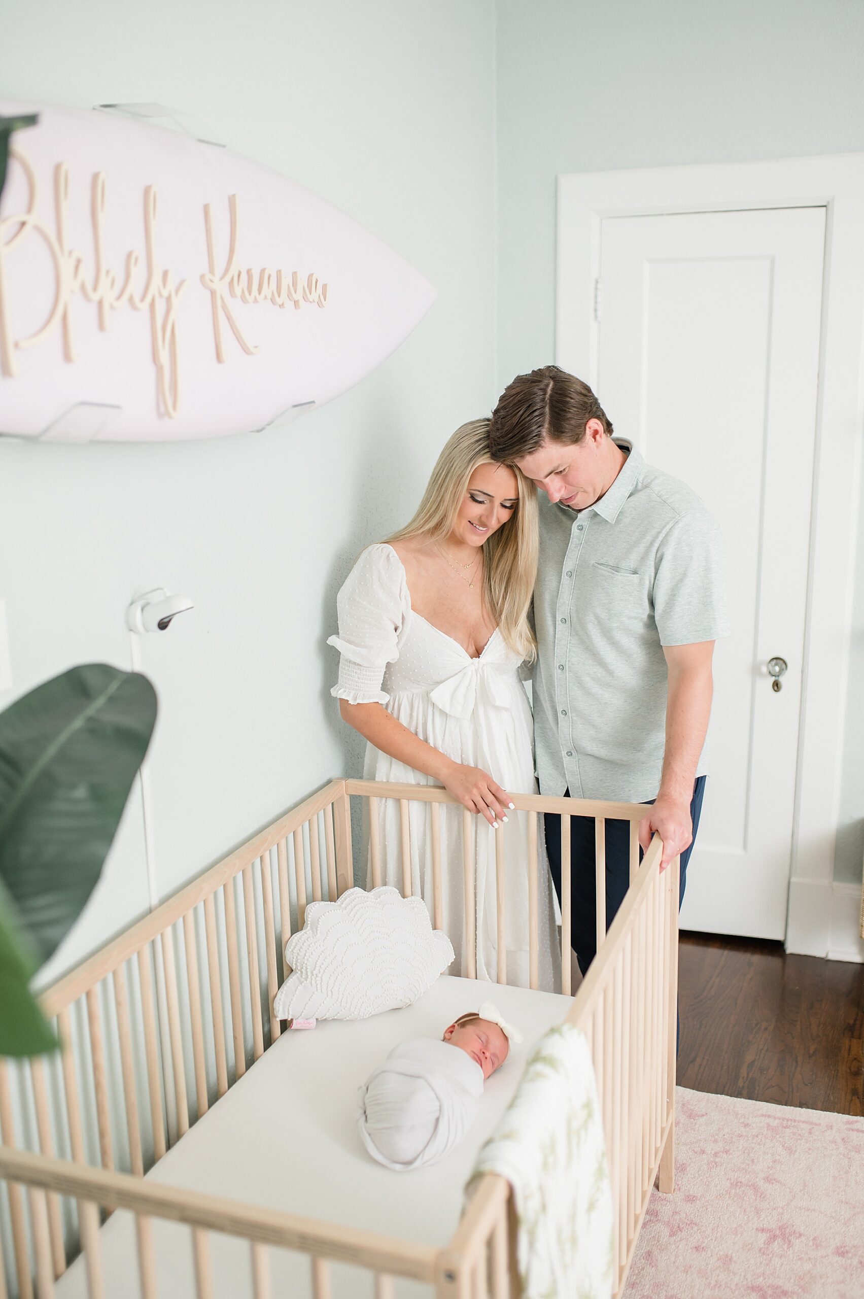 parents look down at newborn girl sleeping in crib photographed by  Dallas Newborn Photographer, Lindsey Dutton Photography