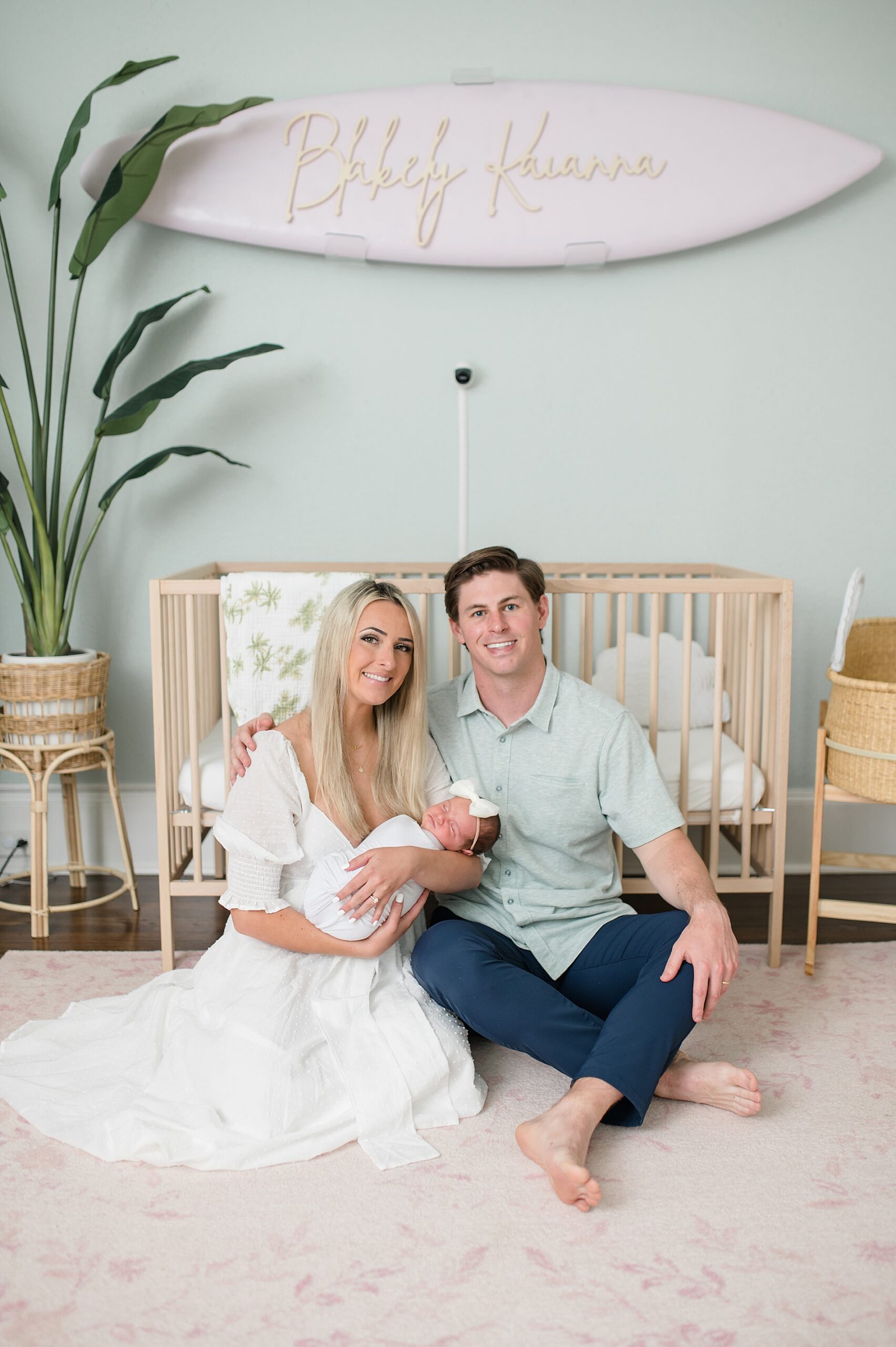 parents sit on floor of nursery holding newborn girl photographed by Dallas Newborn Photographer, Lindsey Dutton Photography