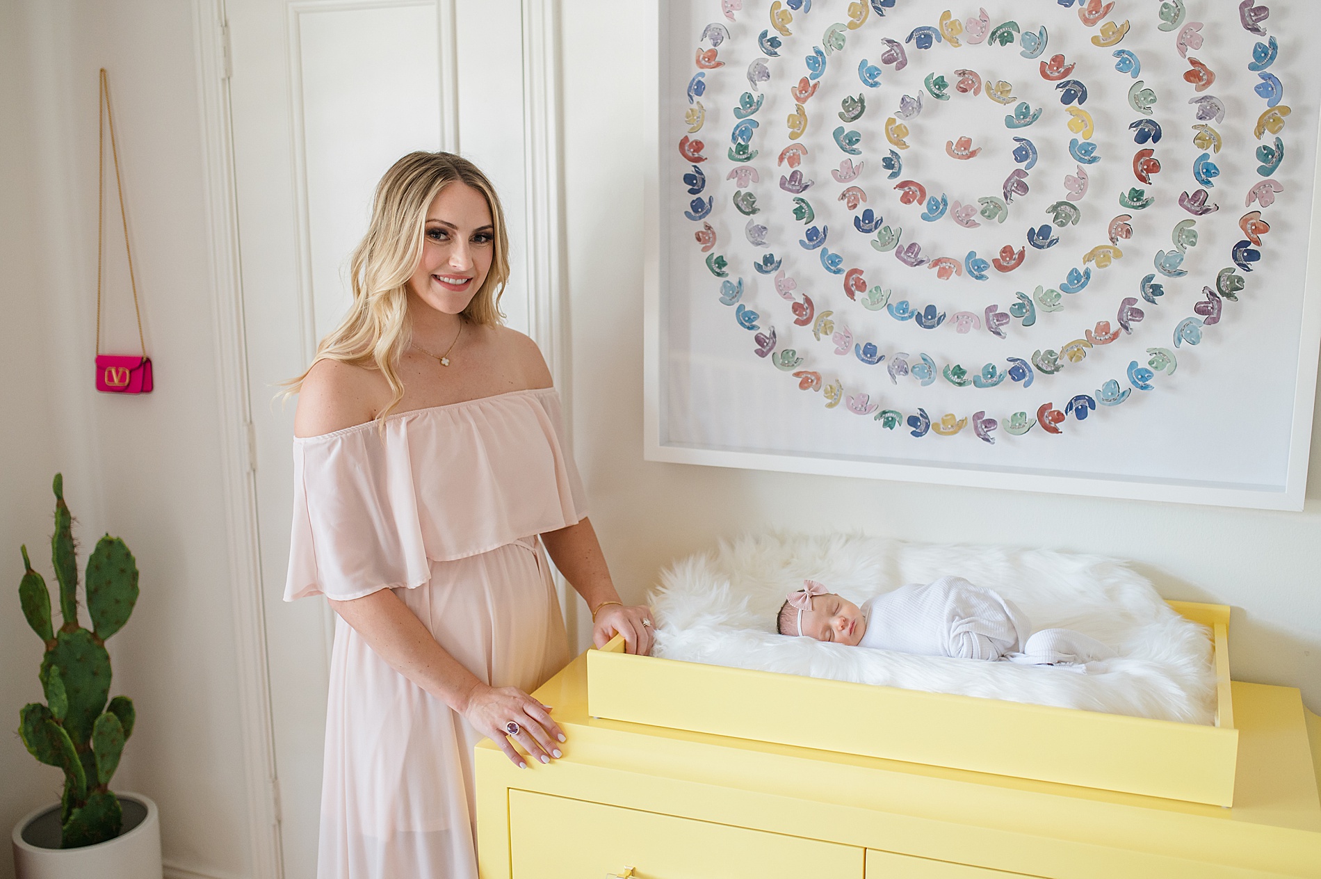 mom stands near baby girl in changing table taken by Lindsey Dutton Photography, a Dallas newborn photographer
