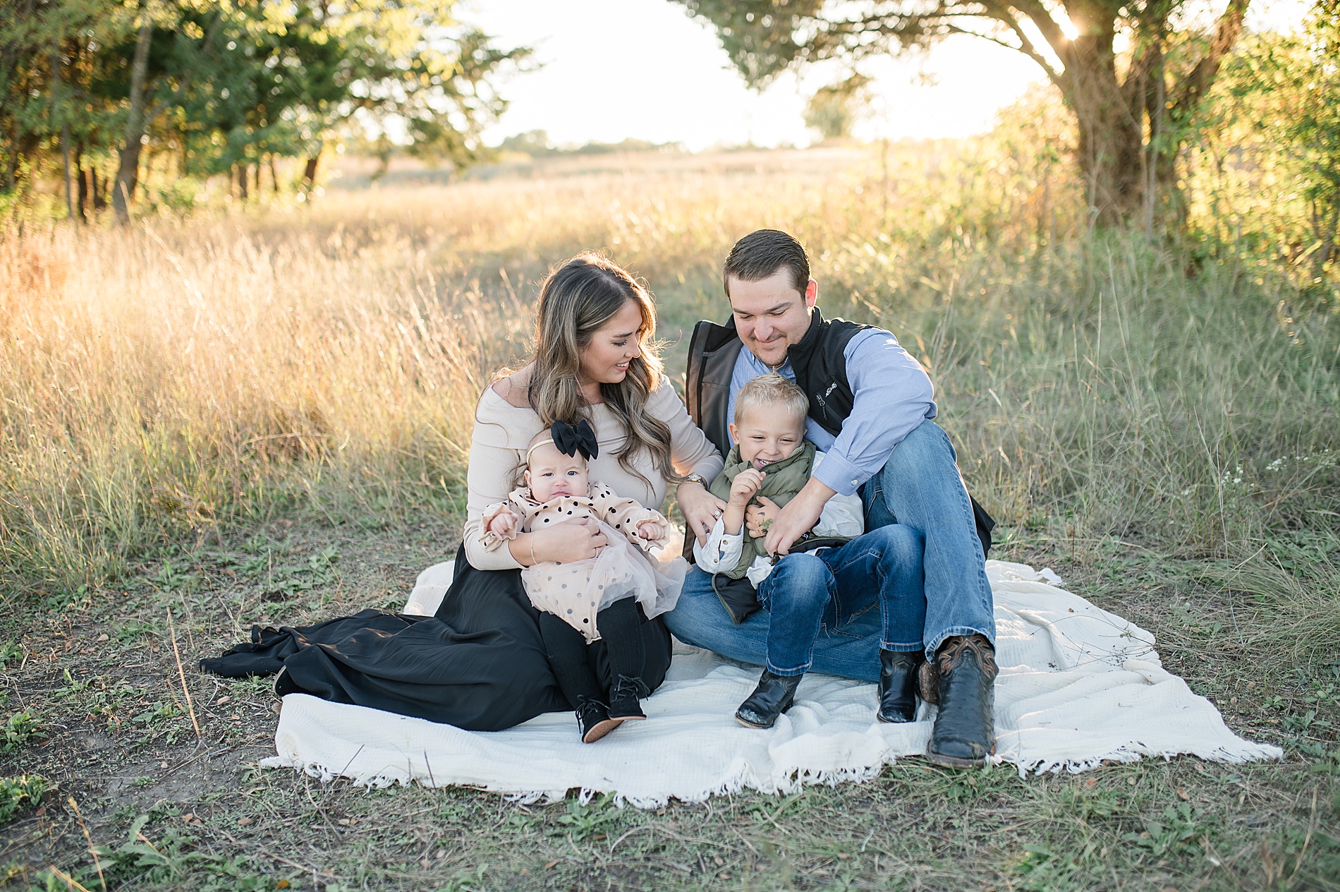 family of four sit on blanket at Erwin Park photographed by Lindsey Dutton Photography, a Dallas Family photographer
