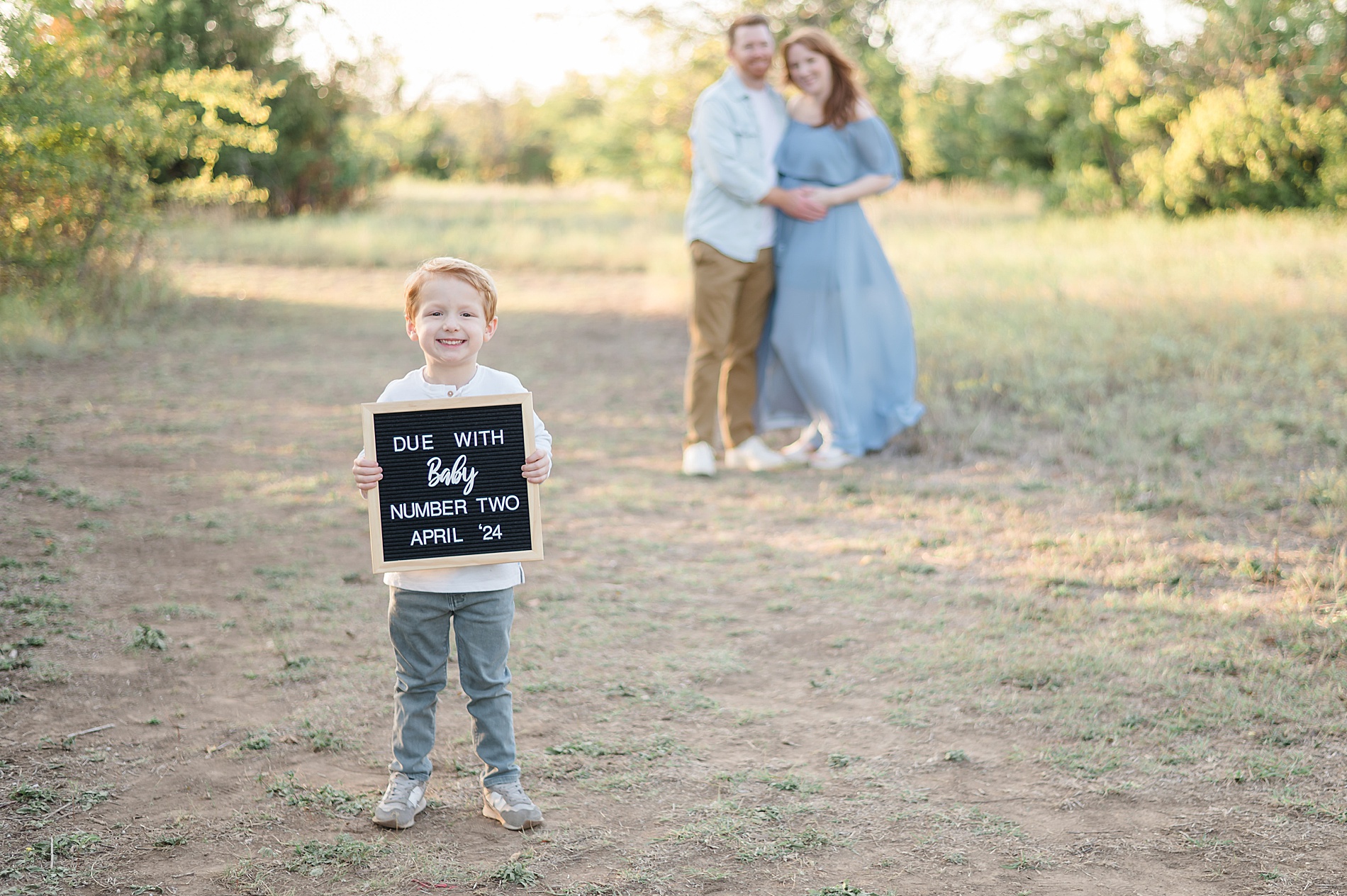boy holds up sign during pregnancy announcement photoshoot photographed by Lindsey Dutton Photography, a Dallas maternity photographer
