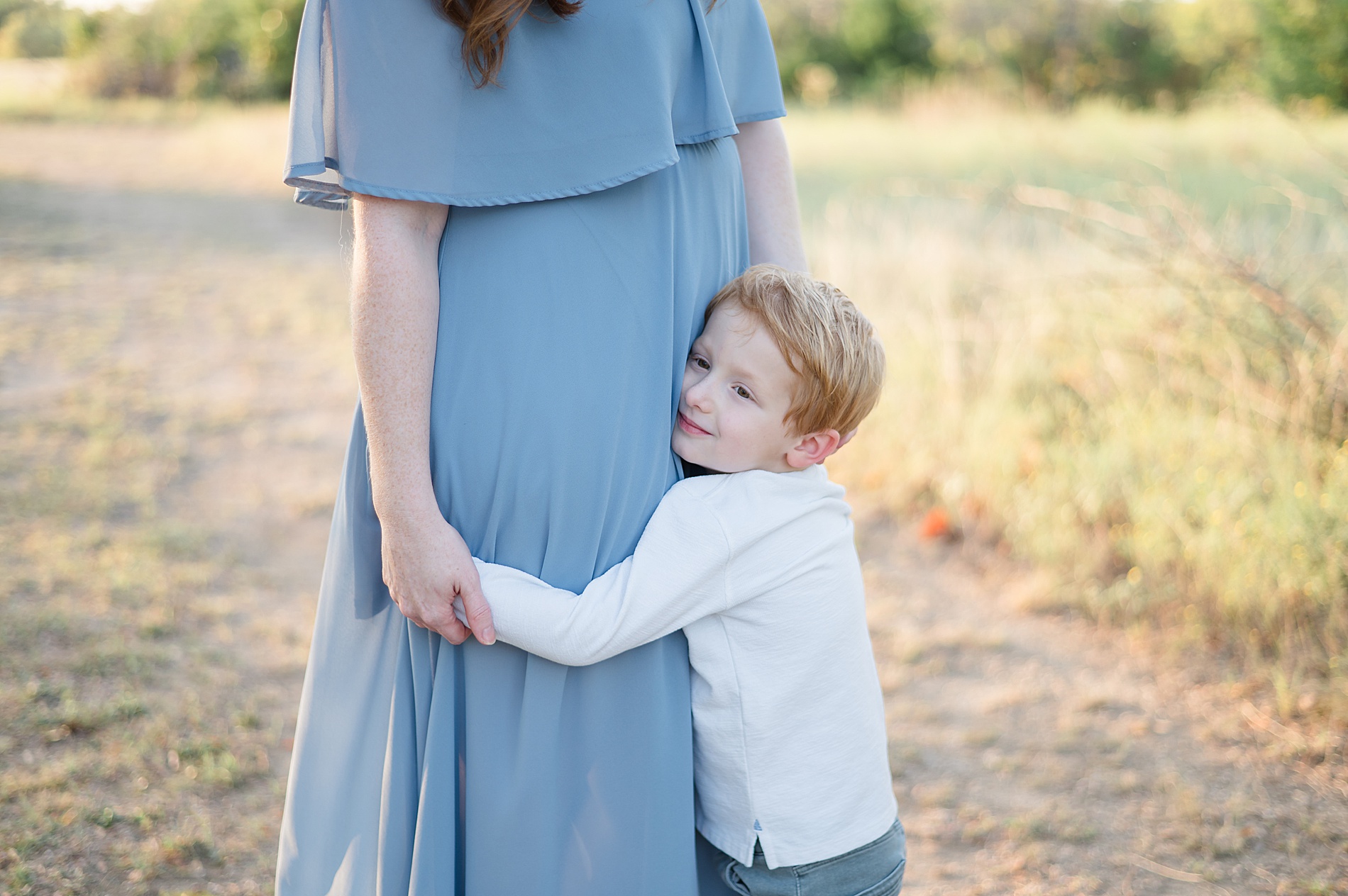 little boy hugs his pregnant mom taken by Lindsey Dutton Photography, a Dallas maternity photographer
