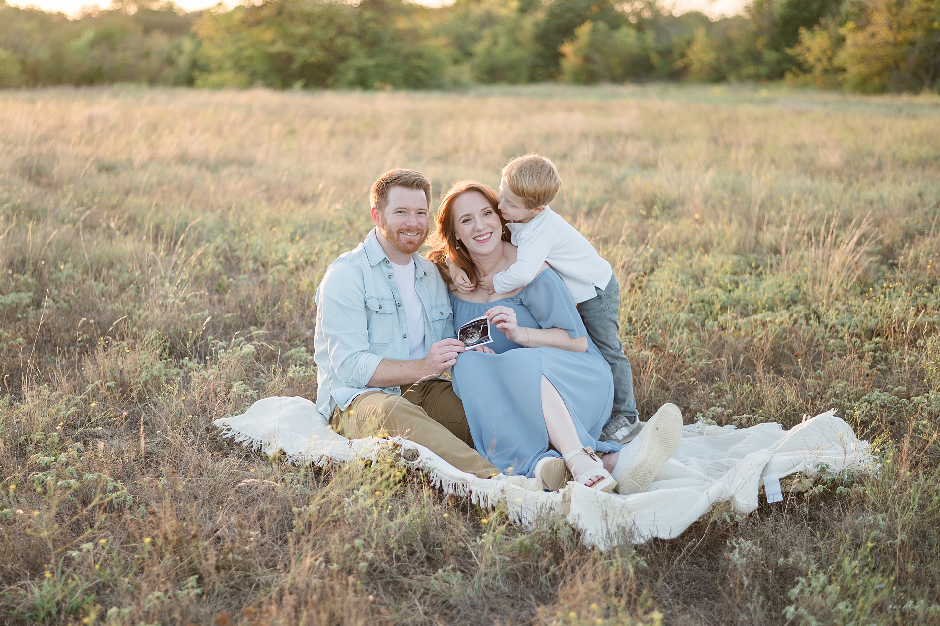 family snuggling at pregnancy announcement photoshoot by Dallas maternity photographer taken by Lindsey Dutton Photography, a Dallas maternity photographer
