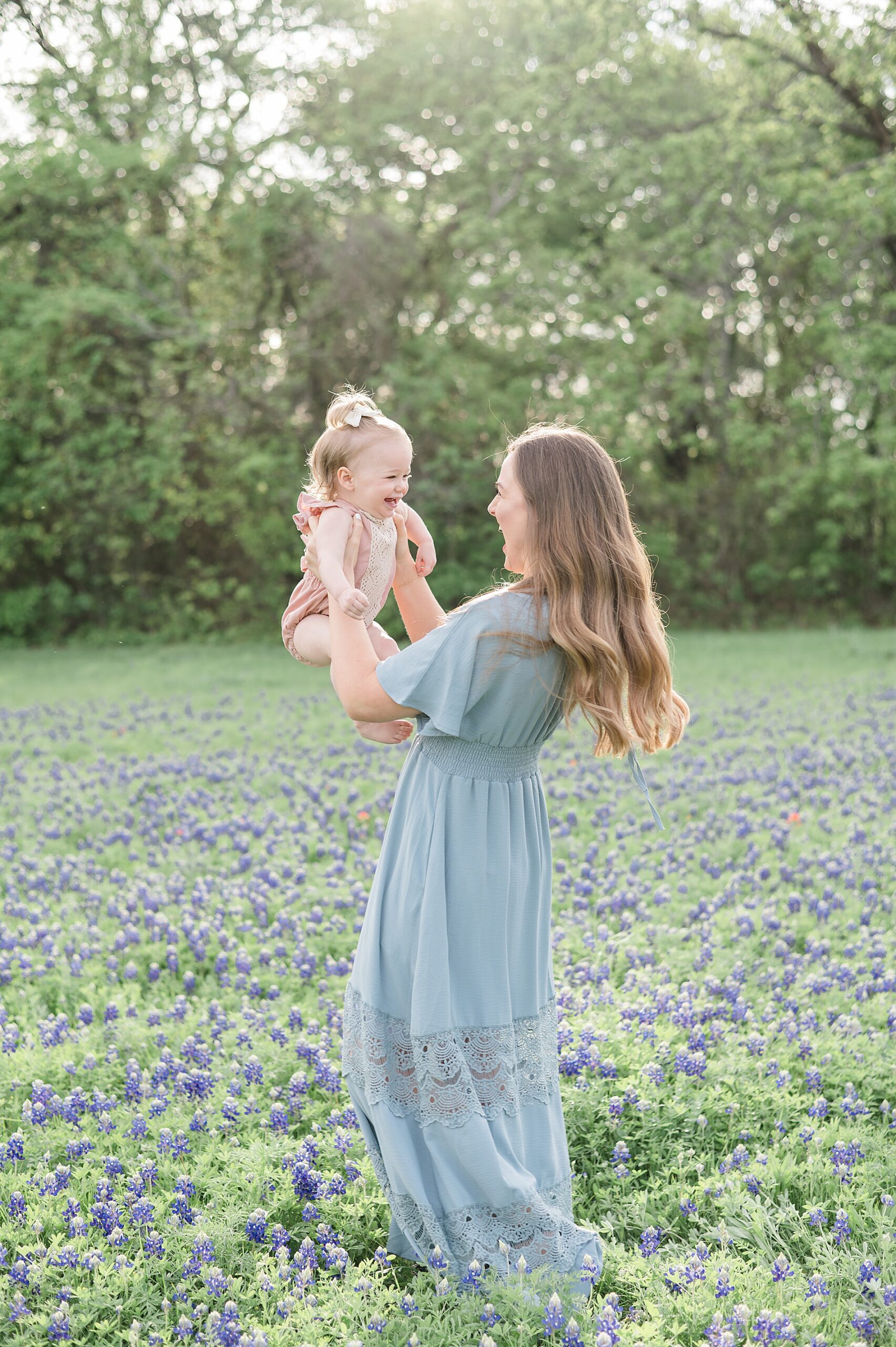 mom holds little girl as she giggles taken by Lindsey Dutton Photography, a Dallas family photographer