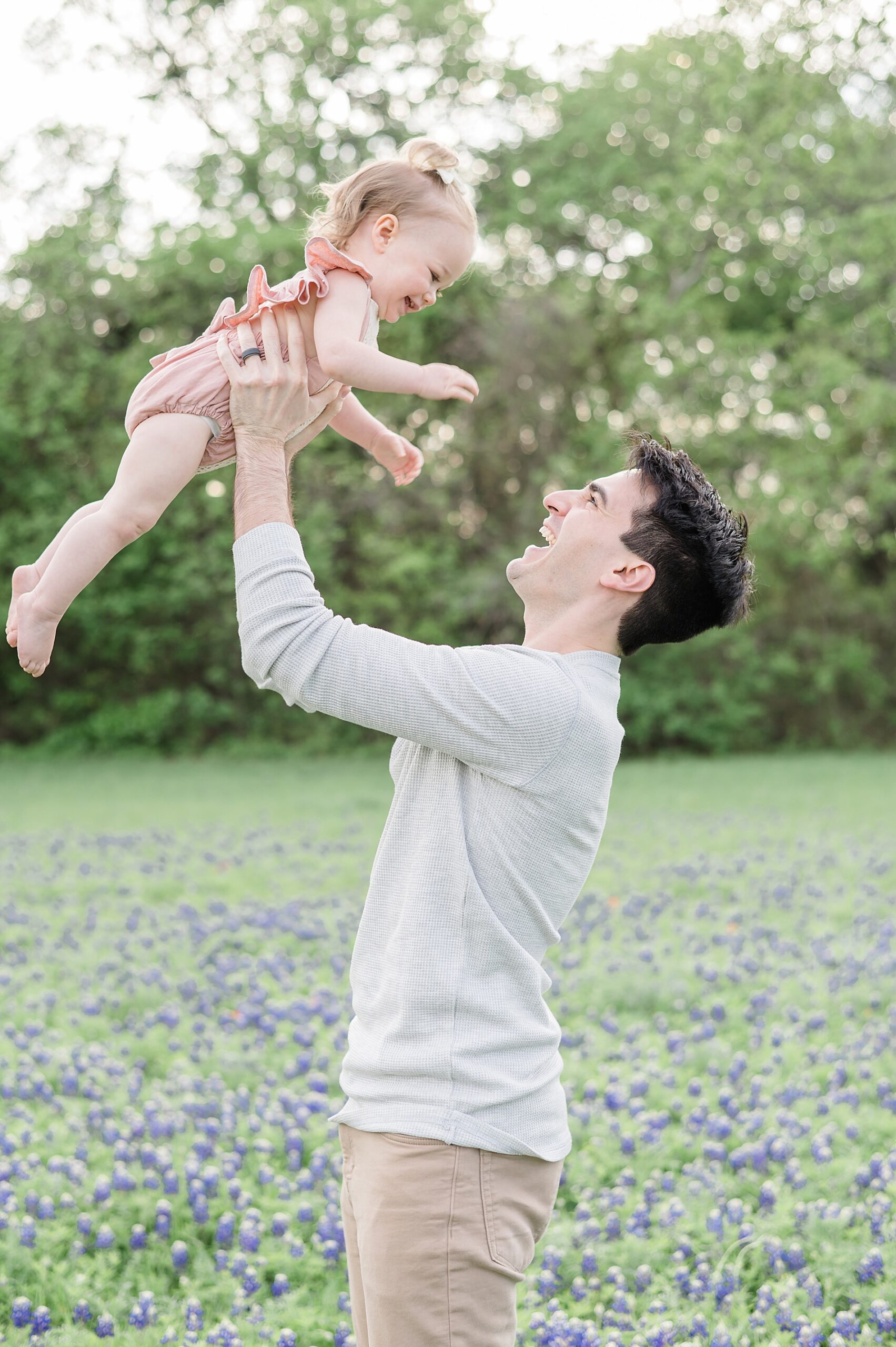 father lifts his little girl in the air taken by Lindsey Dutton Photography, a Dallas family photographer