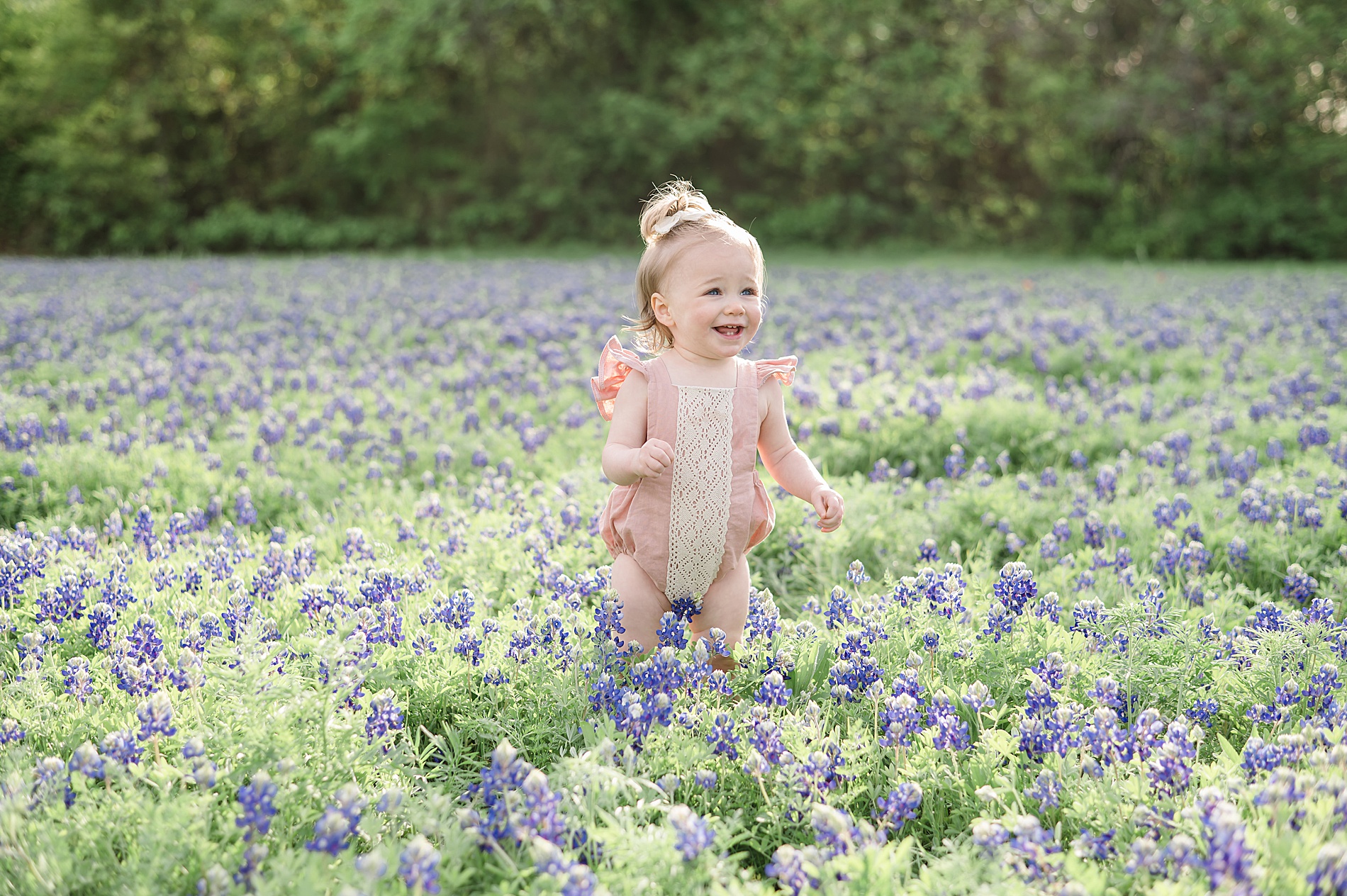 little girl explores field of bluebonnet flowers photographed by Lindsey Dutton Photography, a Dallas family photographer