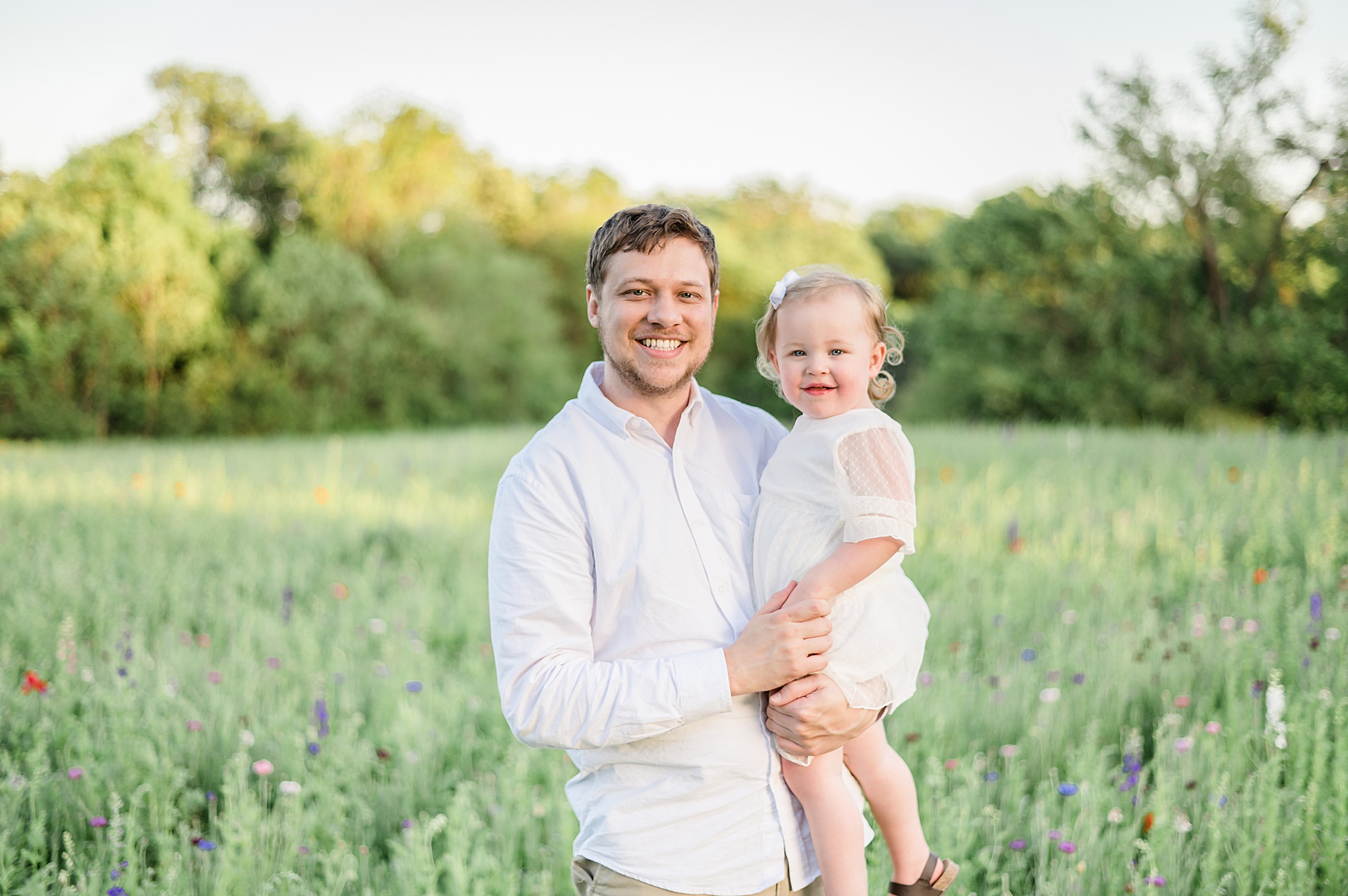 dad holds his daughter during spring family session photographed by Lindsey Dutton Photography, a Dallas family photographer