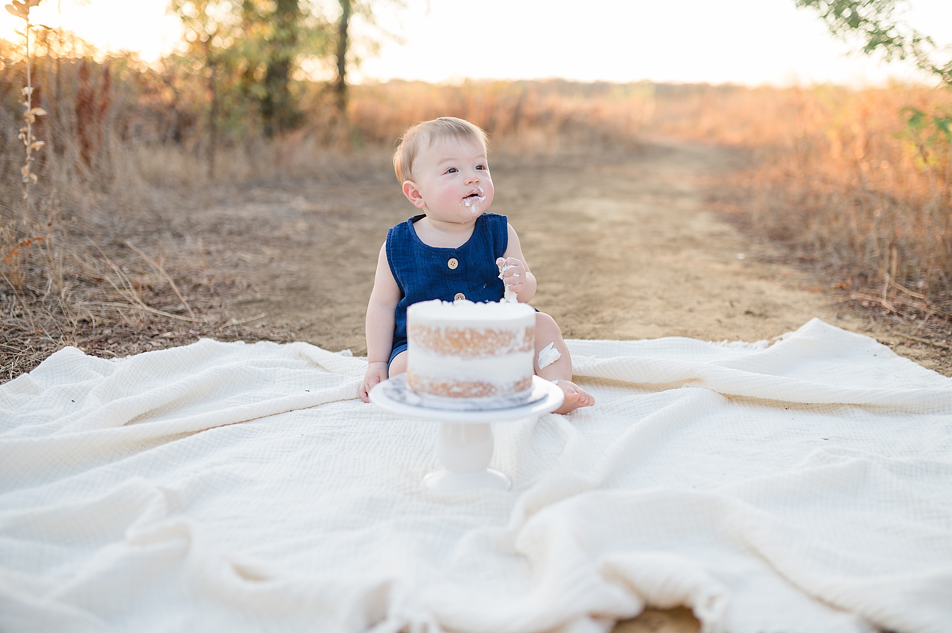little boy during outdoor cake smash taken by Lindsey Dutton Photography, a Dallas newborn photographer

