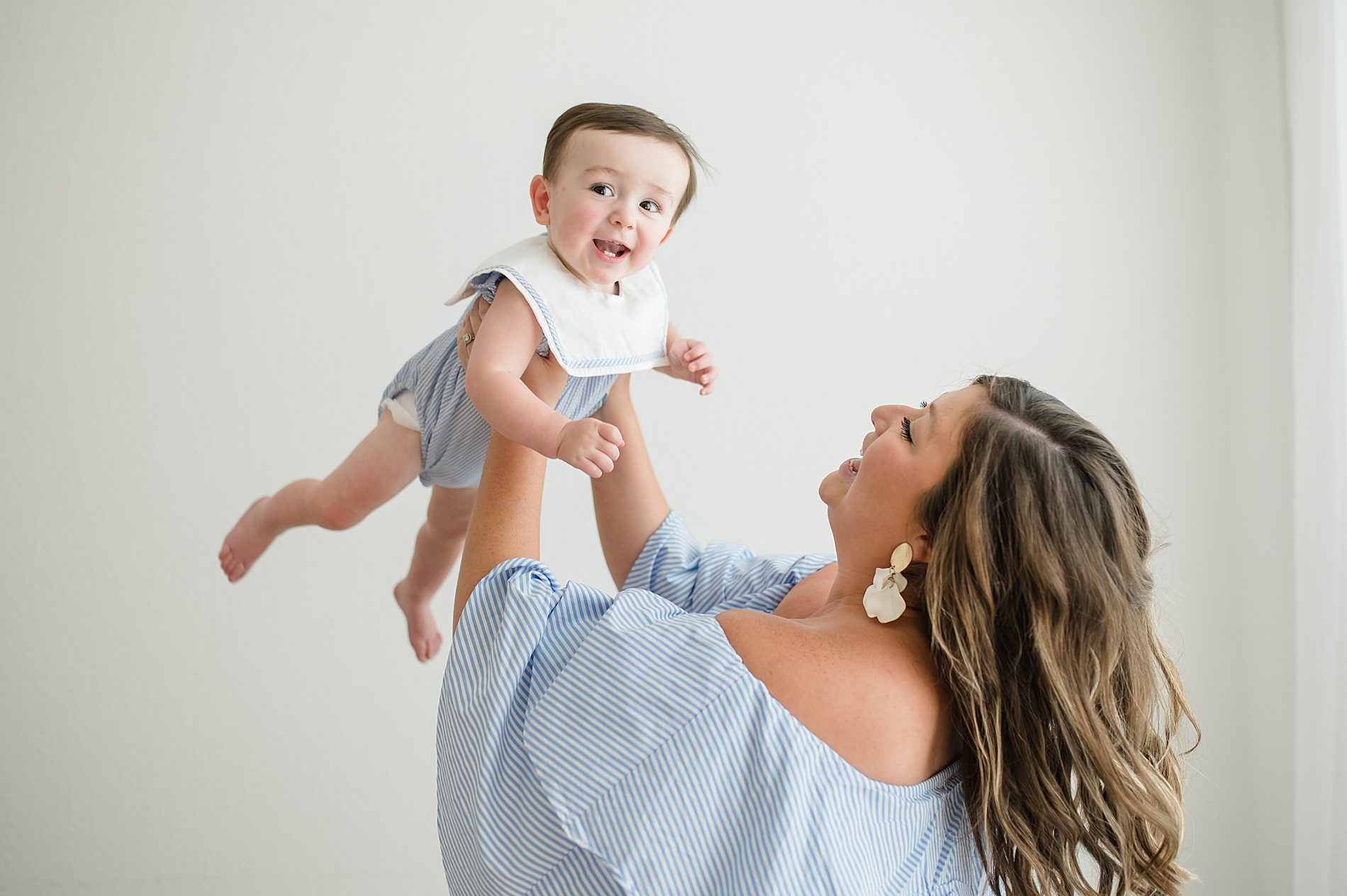 Mom holding son up in the air photographed by Lindsey Dutton Photography, a Dallas newborn photographer
