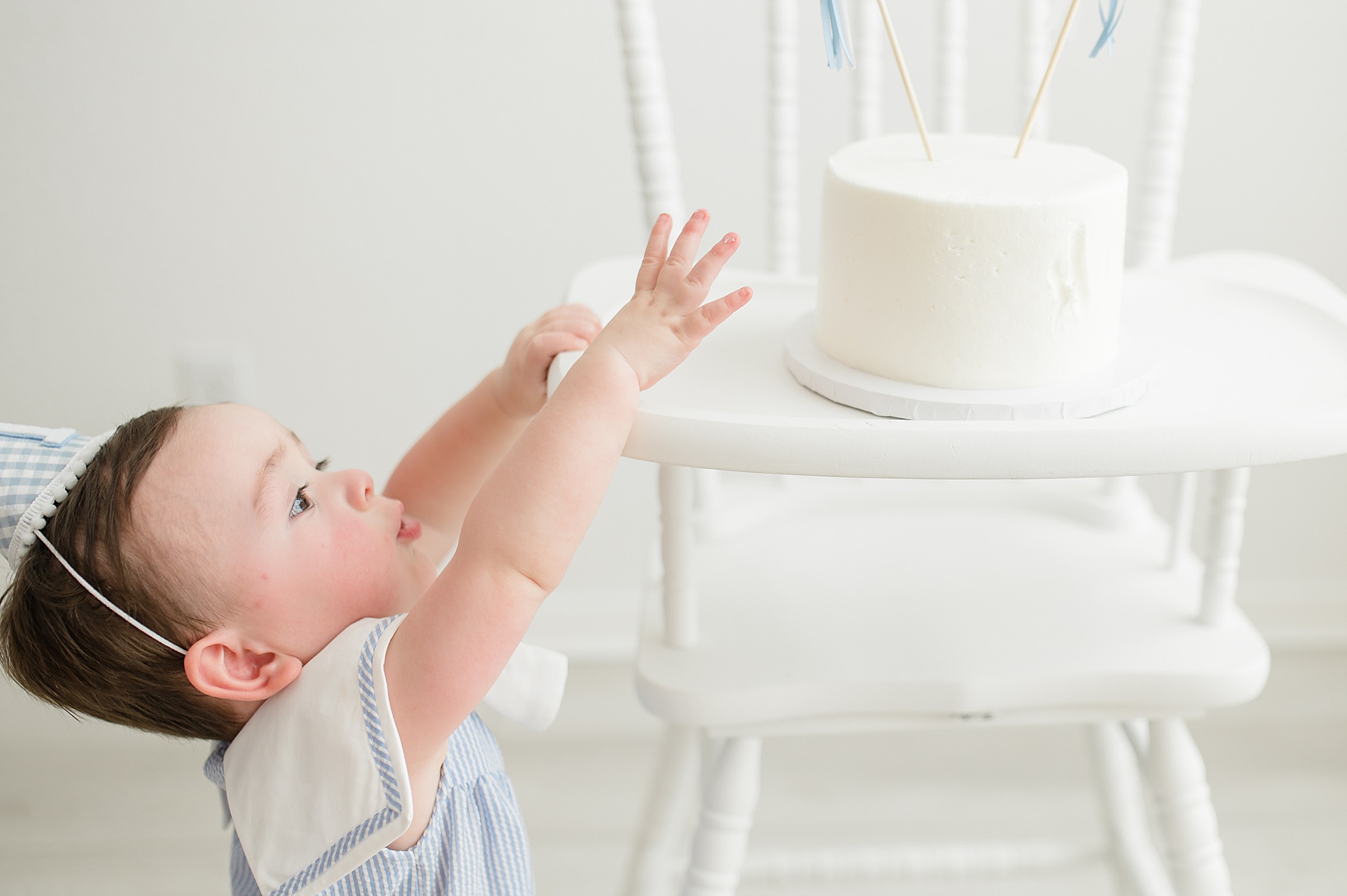 little boy reaches for cake photographed by Lindsey Dutton Photography, a Dallas newborn photographer
