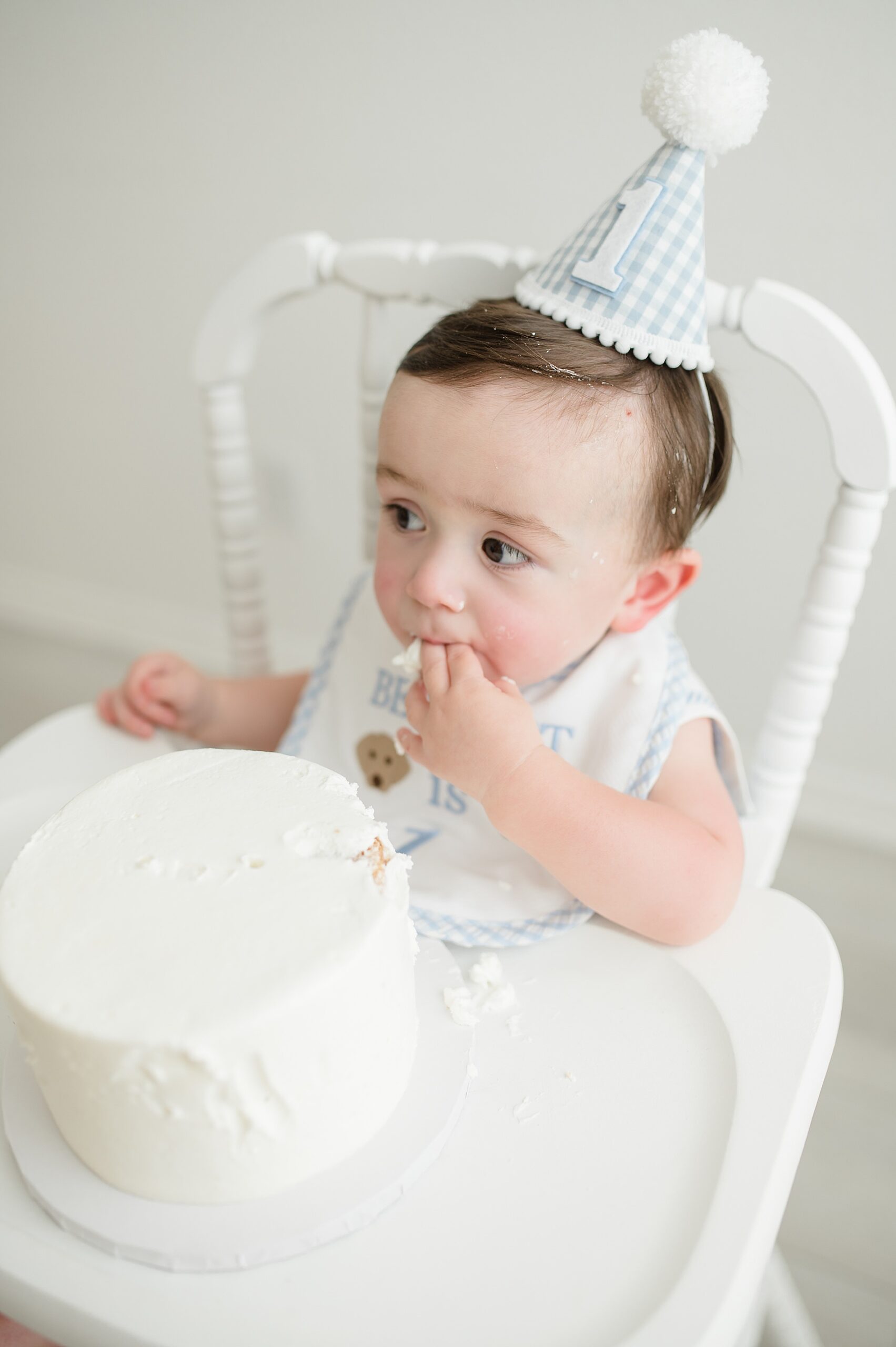 little boy tries cake at indoor cake smash taken by Lindsey Dutton Photography, a Dallas newborn photographer
