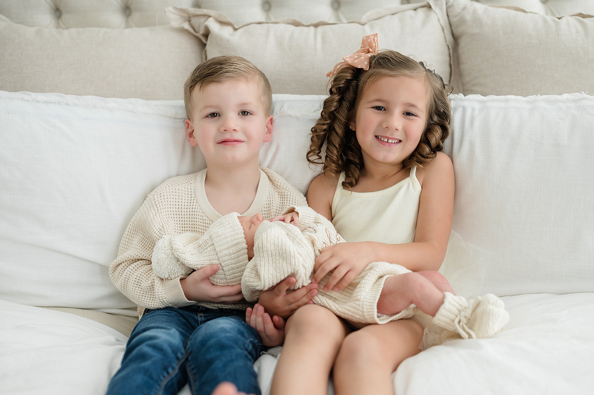 timeless portraits of siblings holder their baby brother taken by Lindsey Dutton Photography, a Dallas newborn photographer
