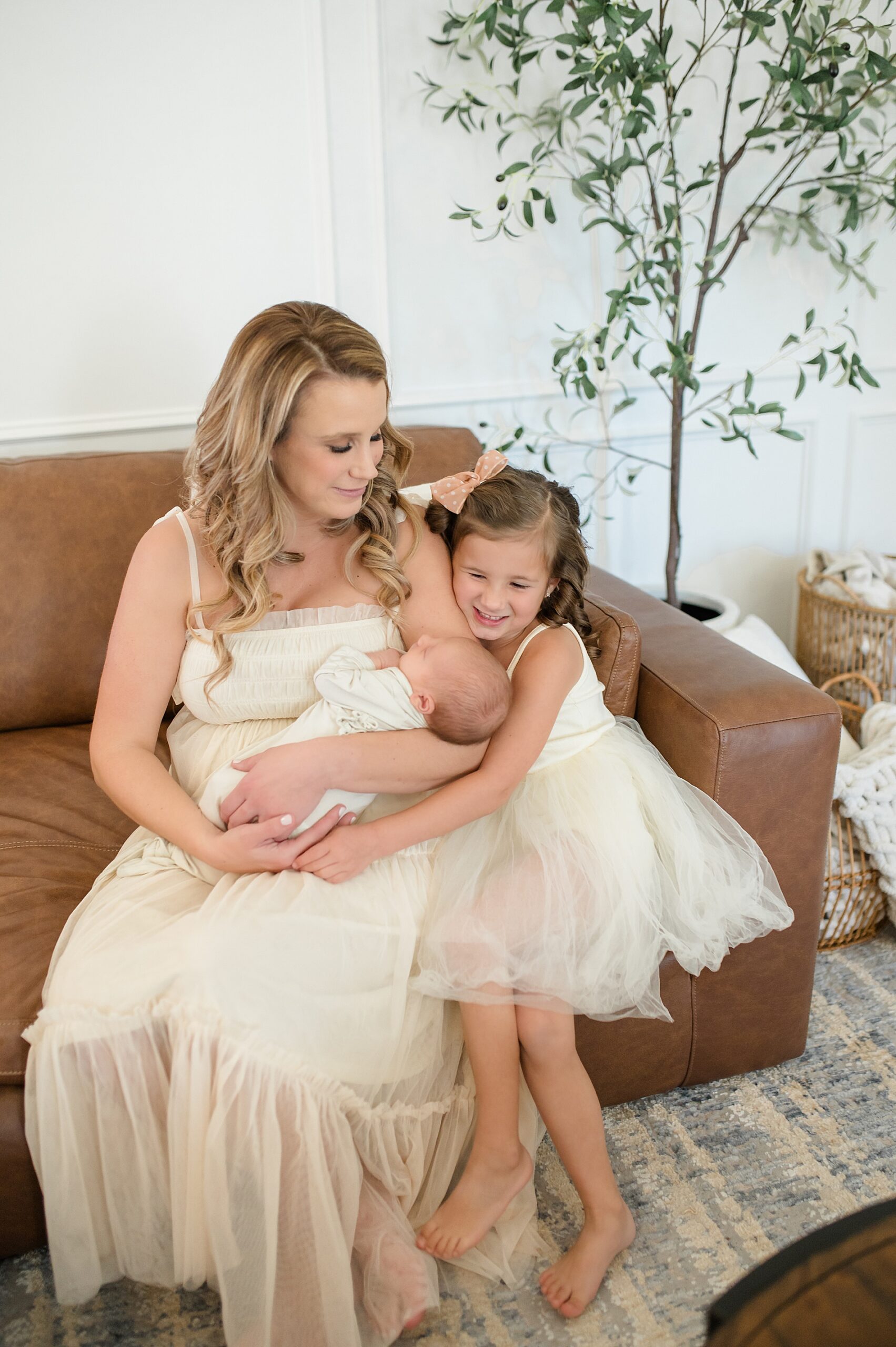 mom holds newborn with older daughter nearby taken by Lindsey Dutton Photography, a Dallas newborn photographer
