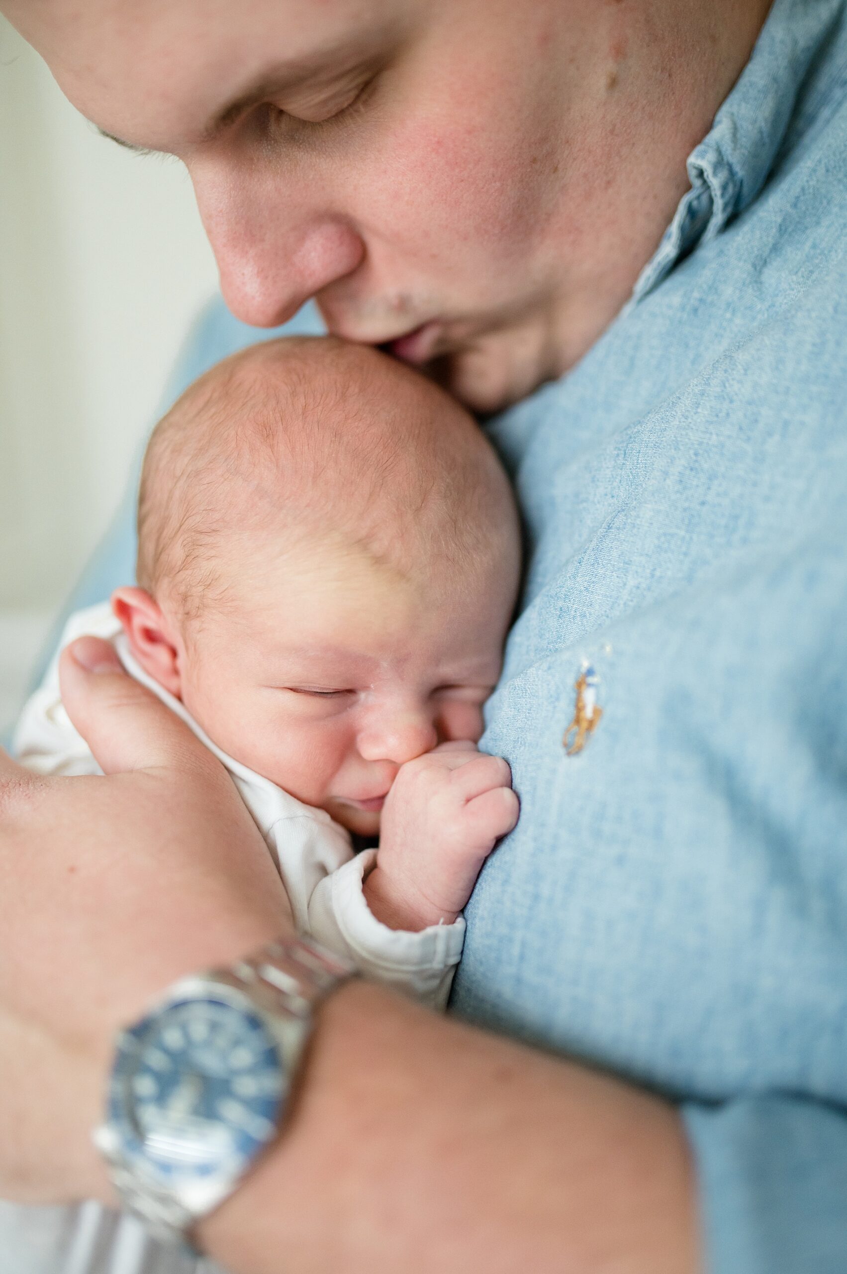 dad kisses newborn's head taken by Lindsey Dutton Photography, a Dallas newborn photographer
