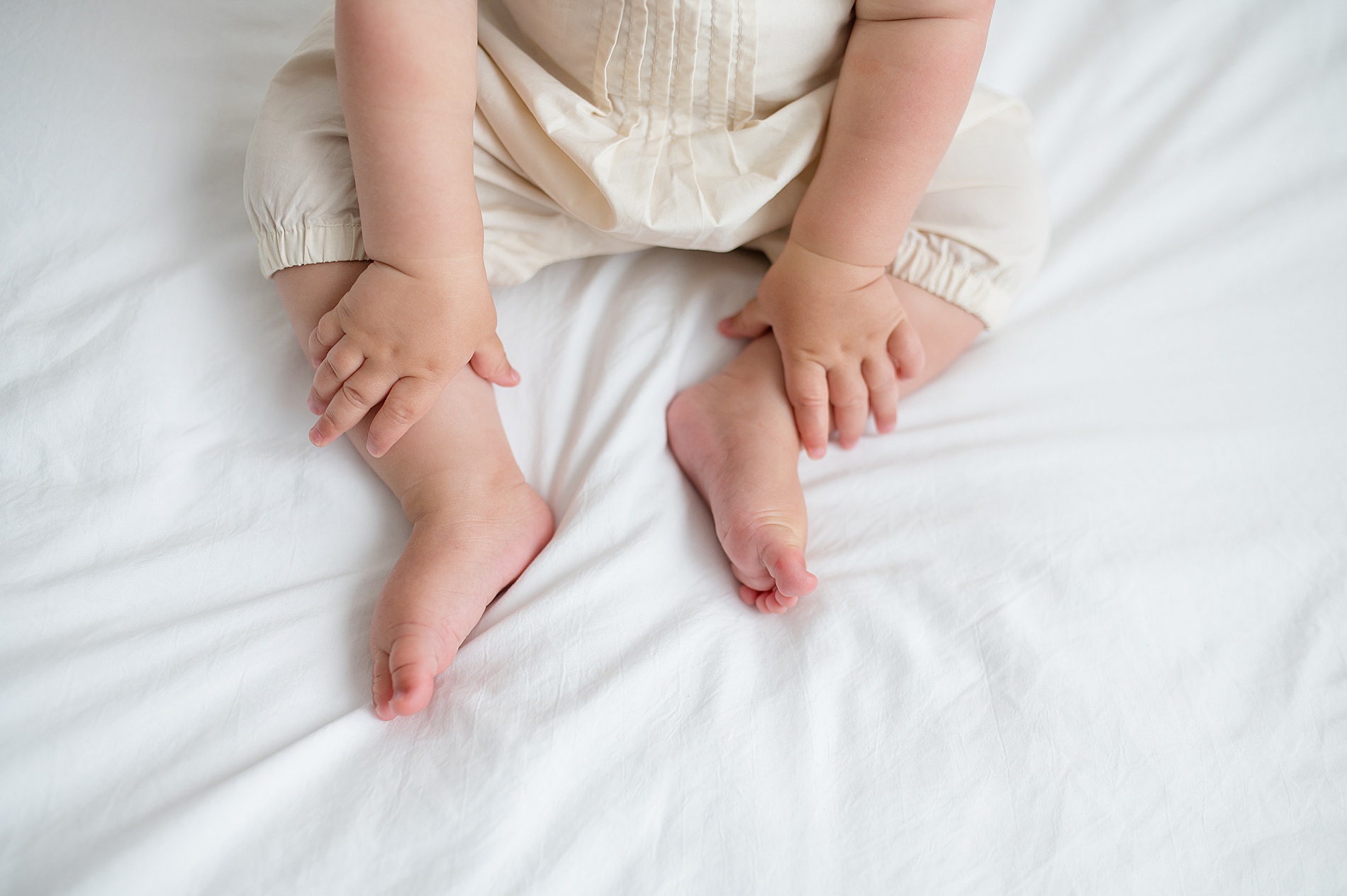 Why Milestone Sessions are a Must-Have for Your Family | Little one sits up on bed photographed by Lindsey Dutton Photography, a Dallas family photographer
