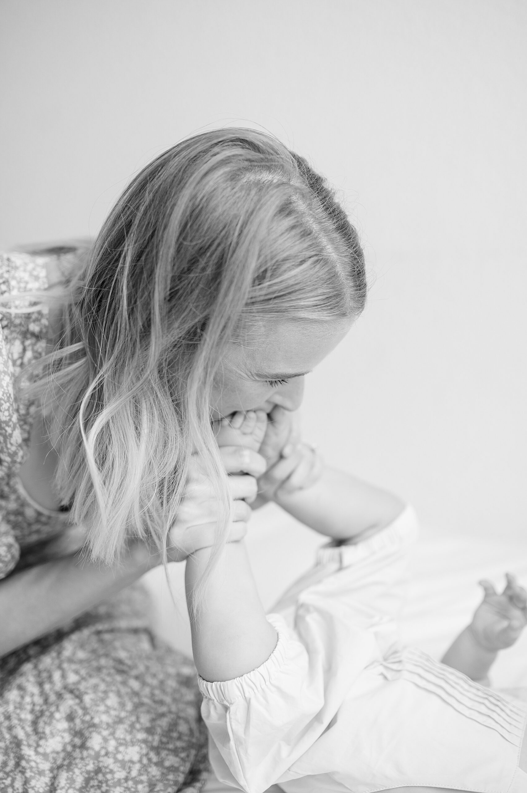 mom kisses baby's feet during milestone session taken by Lindsey Dutton Photography, a Dallas family photographer
