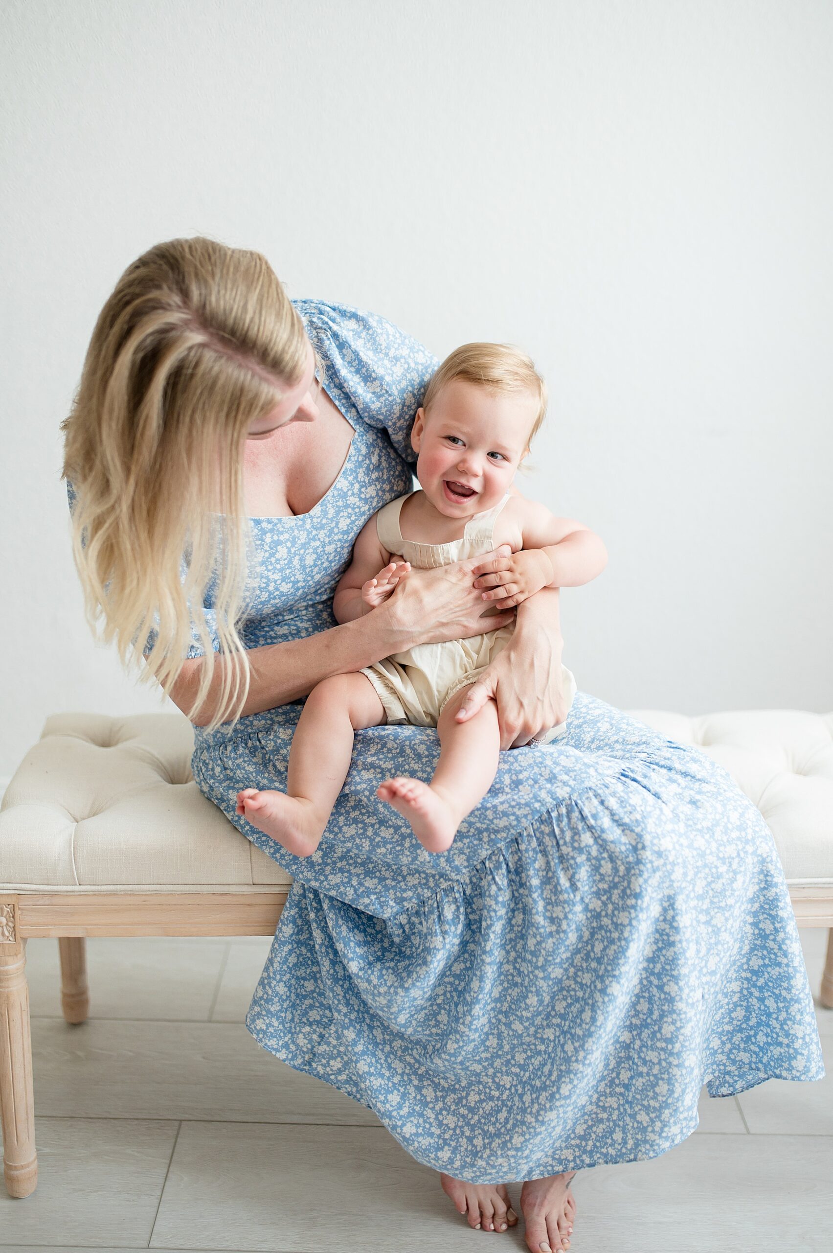 little one laughs while sitting on mom's lap taken by Lindsey Dutton Photography, a Dallas family photographer
