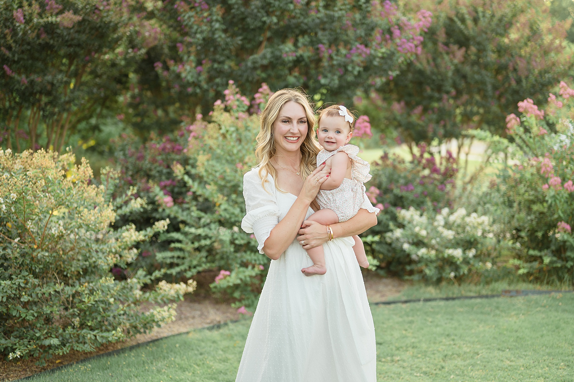 mom holds baby girl from Summer Crepe Myrtle Family Session taken by Lindsey Dutton Photography, a Dallas family photographer
