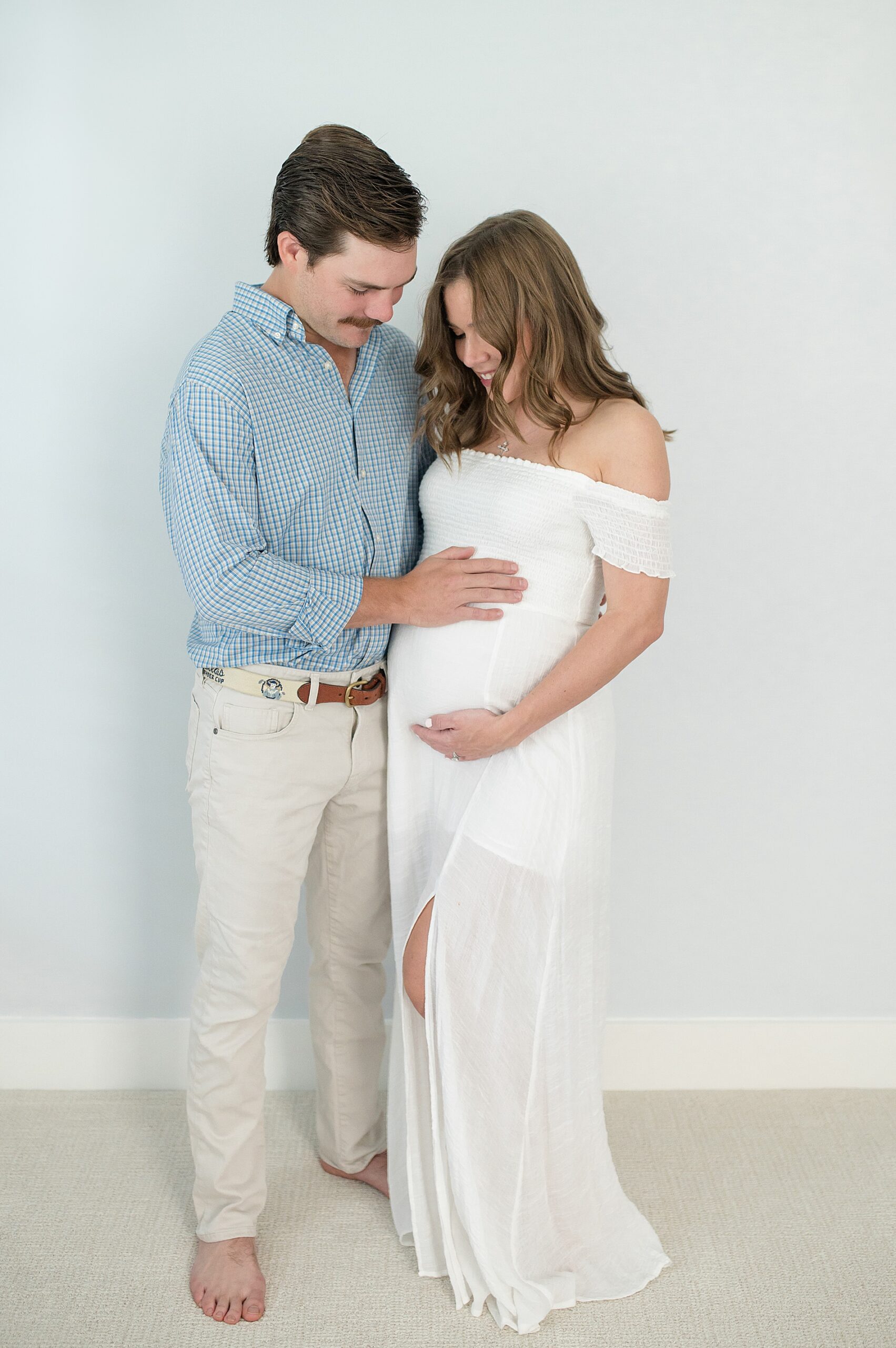 dad puts hand on wife's baby bump during candid maternity photos taken by Lindsey Dutton Photography, a Dallas Maternity photographer
