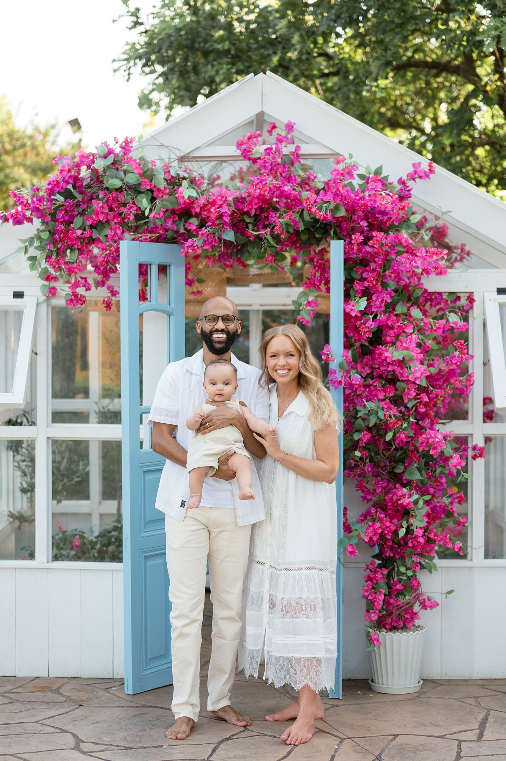 Family smiling at greenhouse at Lemon Drop Studios photographed by Lindsey Dutton Photography, a Dallas Family photographer
