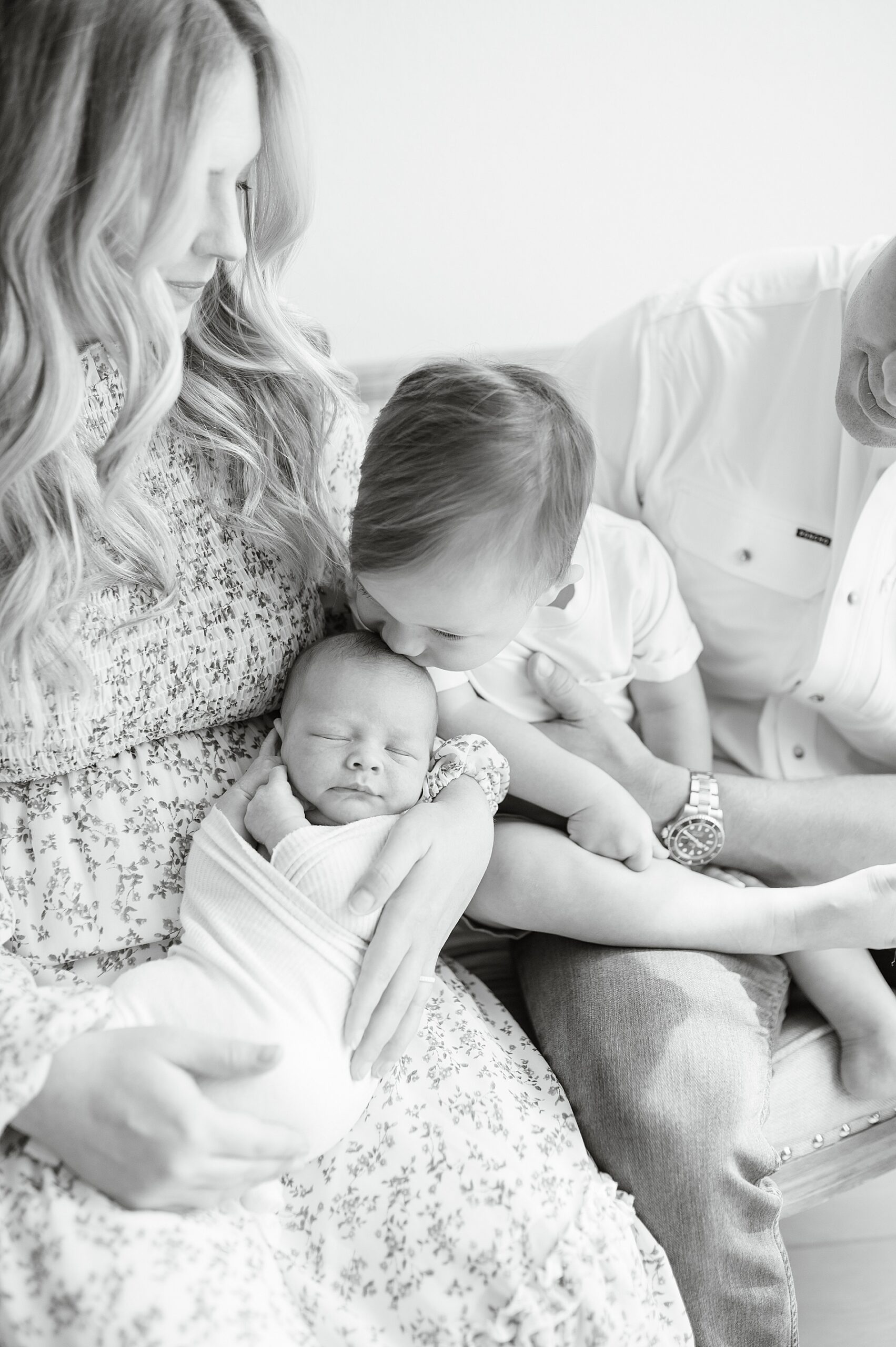 big brother kisses baby brother's head during family photo taken by Lindsey Dutton Photography, a Dallas Newborn photographer