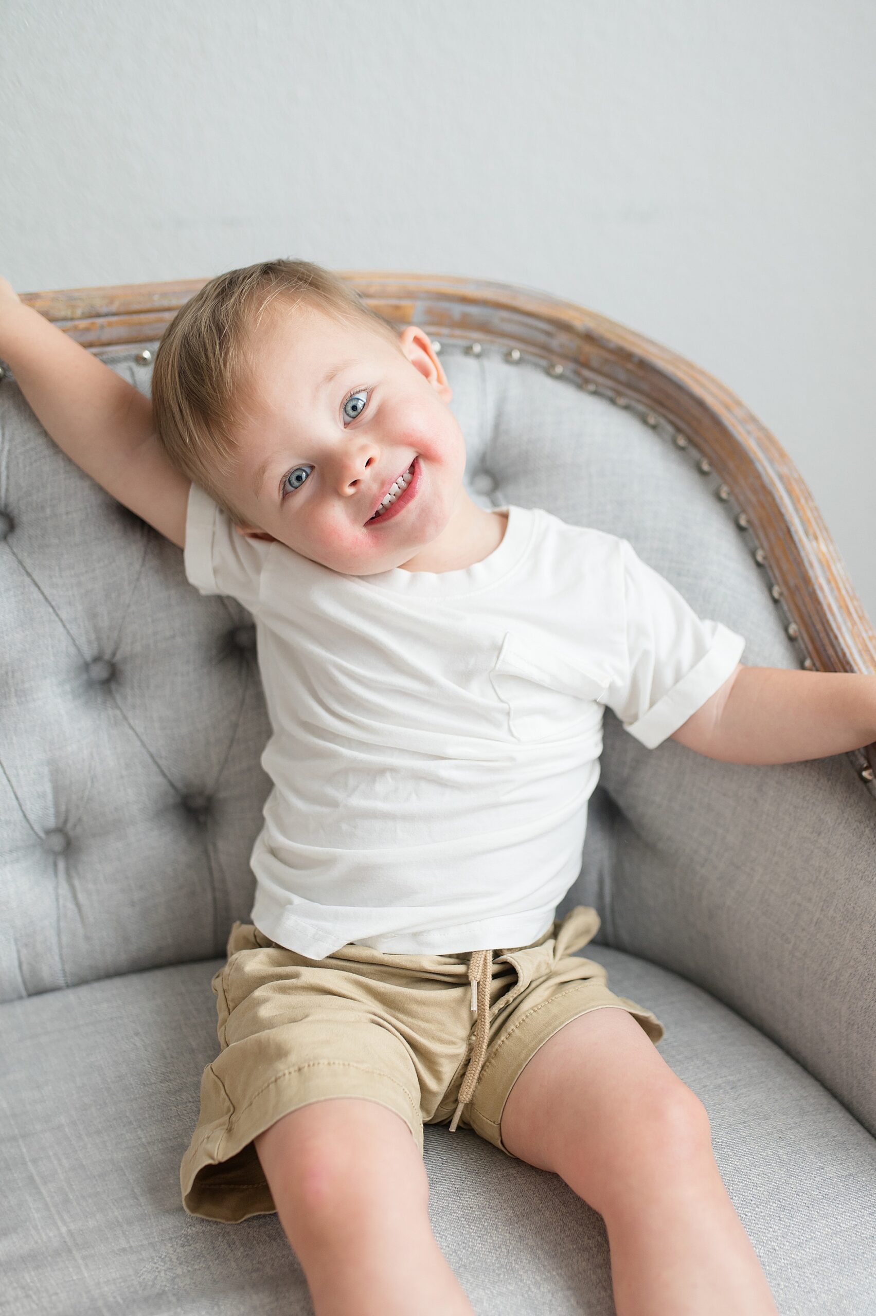 big brother sits in chair taken by Lindsey Dutton Photography, a Dallas Newborn photographer