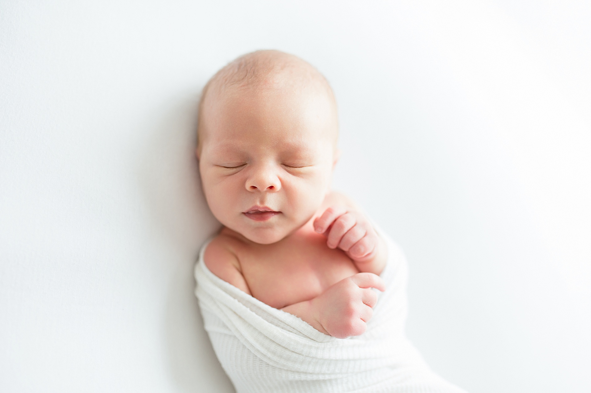 newborn sleeps swaddled in white blanket from Simple Studio Newborn Session in Dallas, Texas taken by Lindsey Dutton Photography, a Dallas Newborn photographer