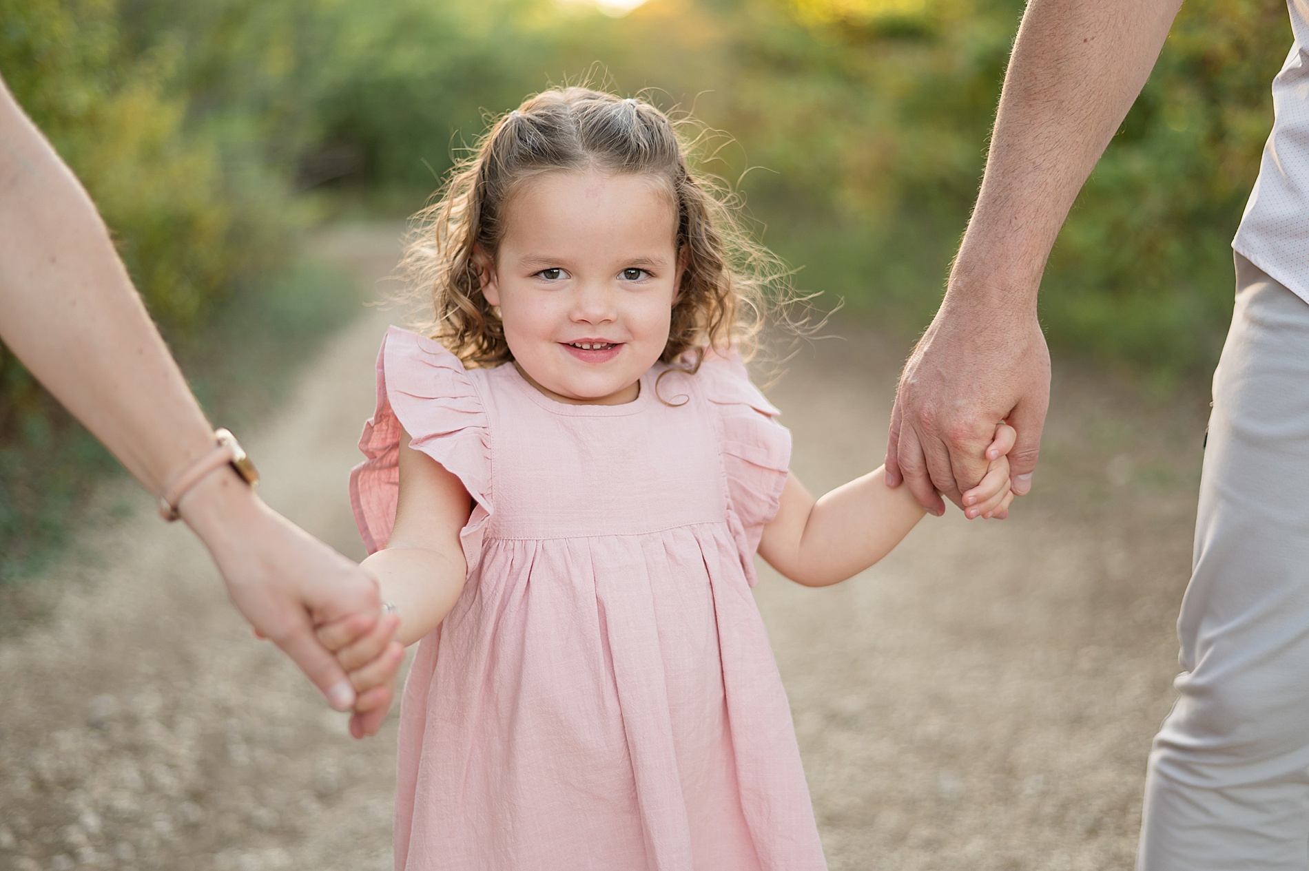 little girl holds her parents' hands photographed by Lindsey Dutton Photography, a Dallas Family photographer