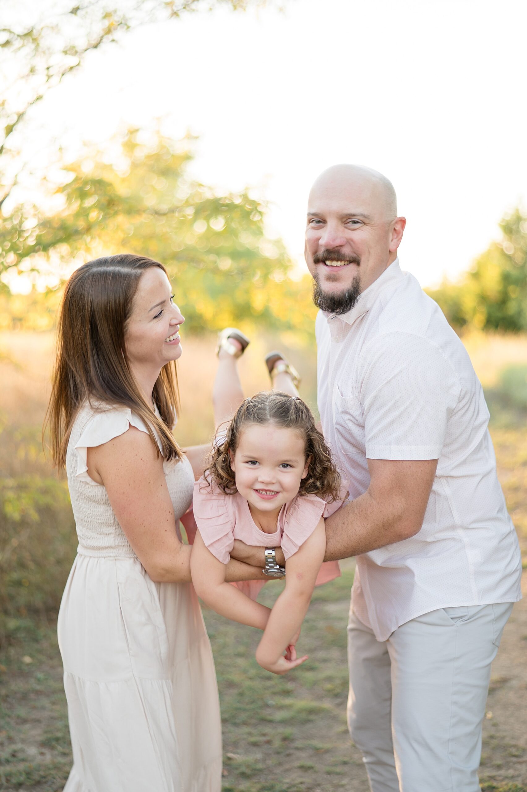 Parents swing little girl photographed by Lindsey Dutton Photography, a Dallas Family photographer
