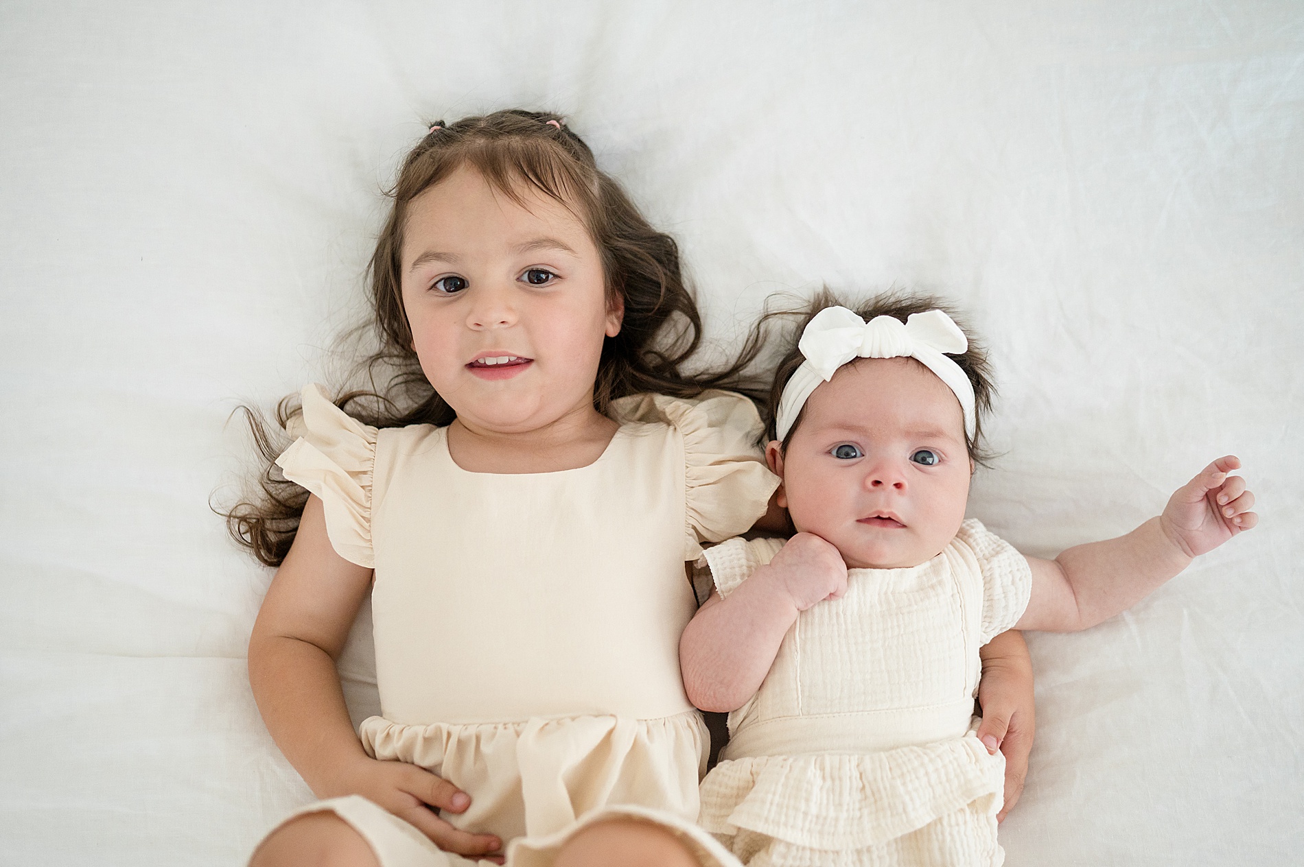 sisters lay together during family session at Beverly Harris House in  by Family Photographer in McKinney, TX