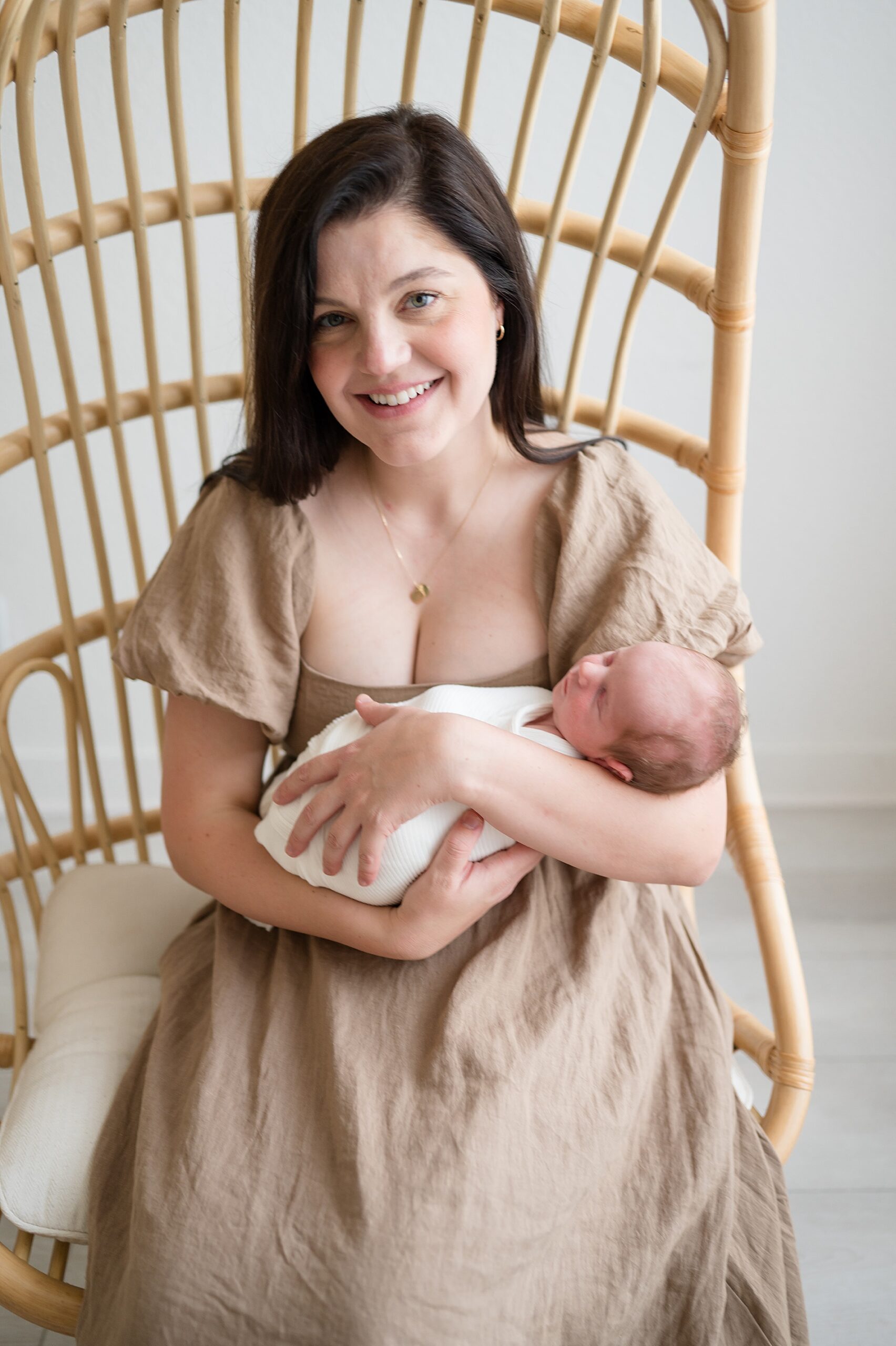 mom holds newborn during Frisco Texas newborn photography session