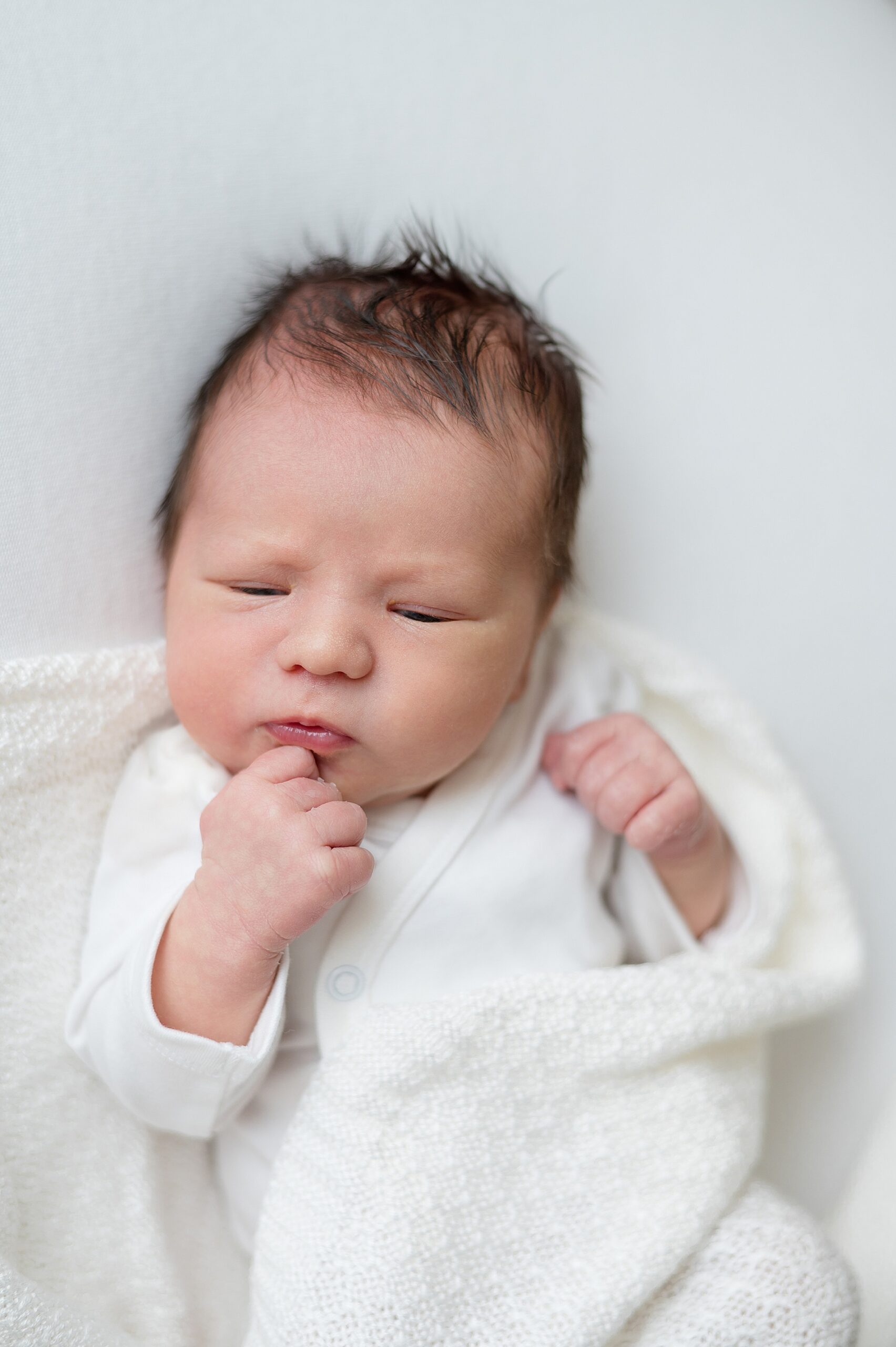 newborn in white blanket